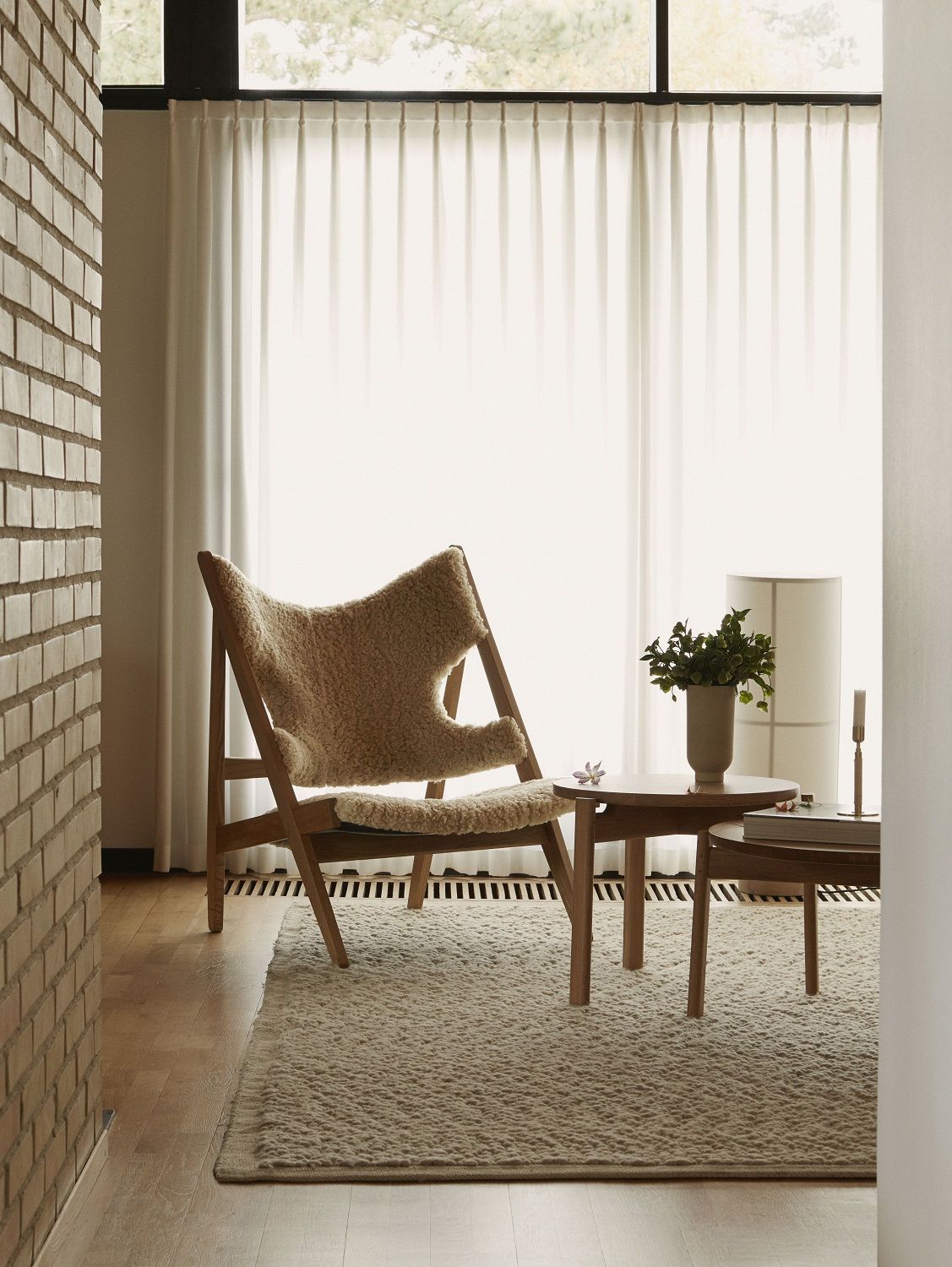 Beiger Gravel Rug Teppich von Audo Copenhagen in einem hellen Wohnzimmer mit Stuhl und Tisch.