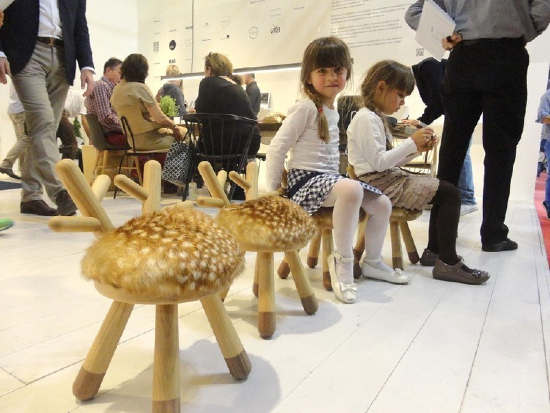 Zwei Mädchen sitzen auf Bambi Chair Kinderstühlen von EO  mit Reh-Optik und Holzbeinen.