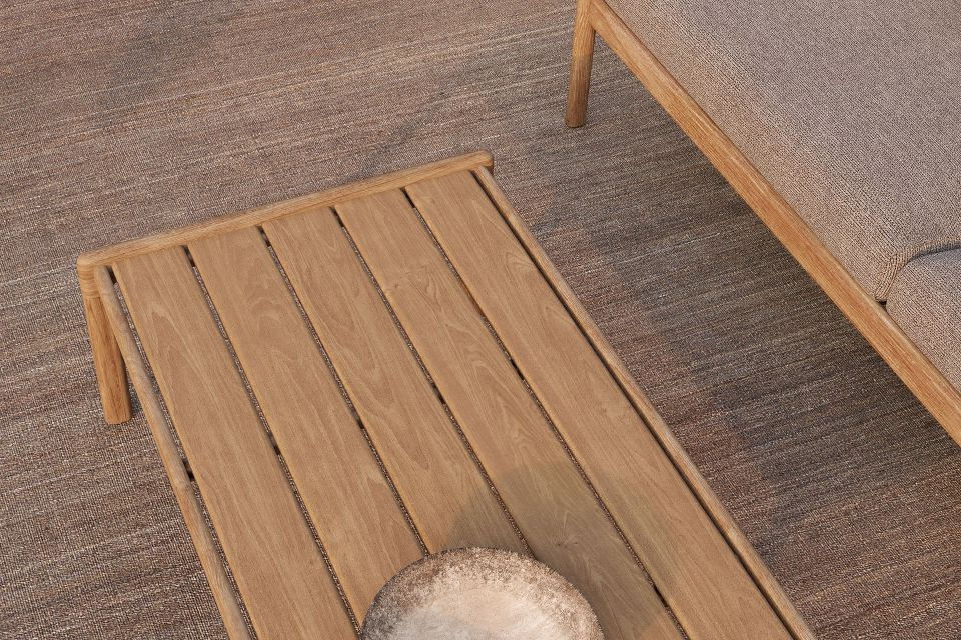 Nahaufnahme des Ethnicraft Jack Outdoor Couchtisches aus Teakholz mit Ablage und Couch.