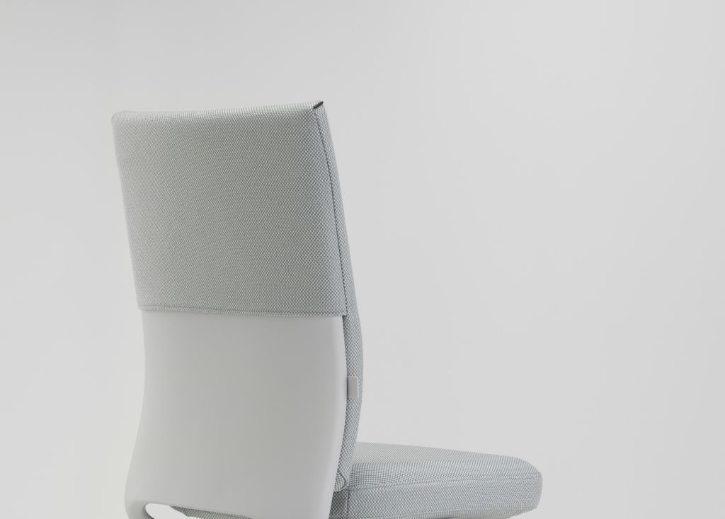 Detailaufnahme der Rückenlehne des Vitra ID Soft Bürodrehstuhls in hellgrauem Stoffbezug und glattem, hellgrauem Kunstleder.