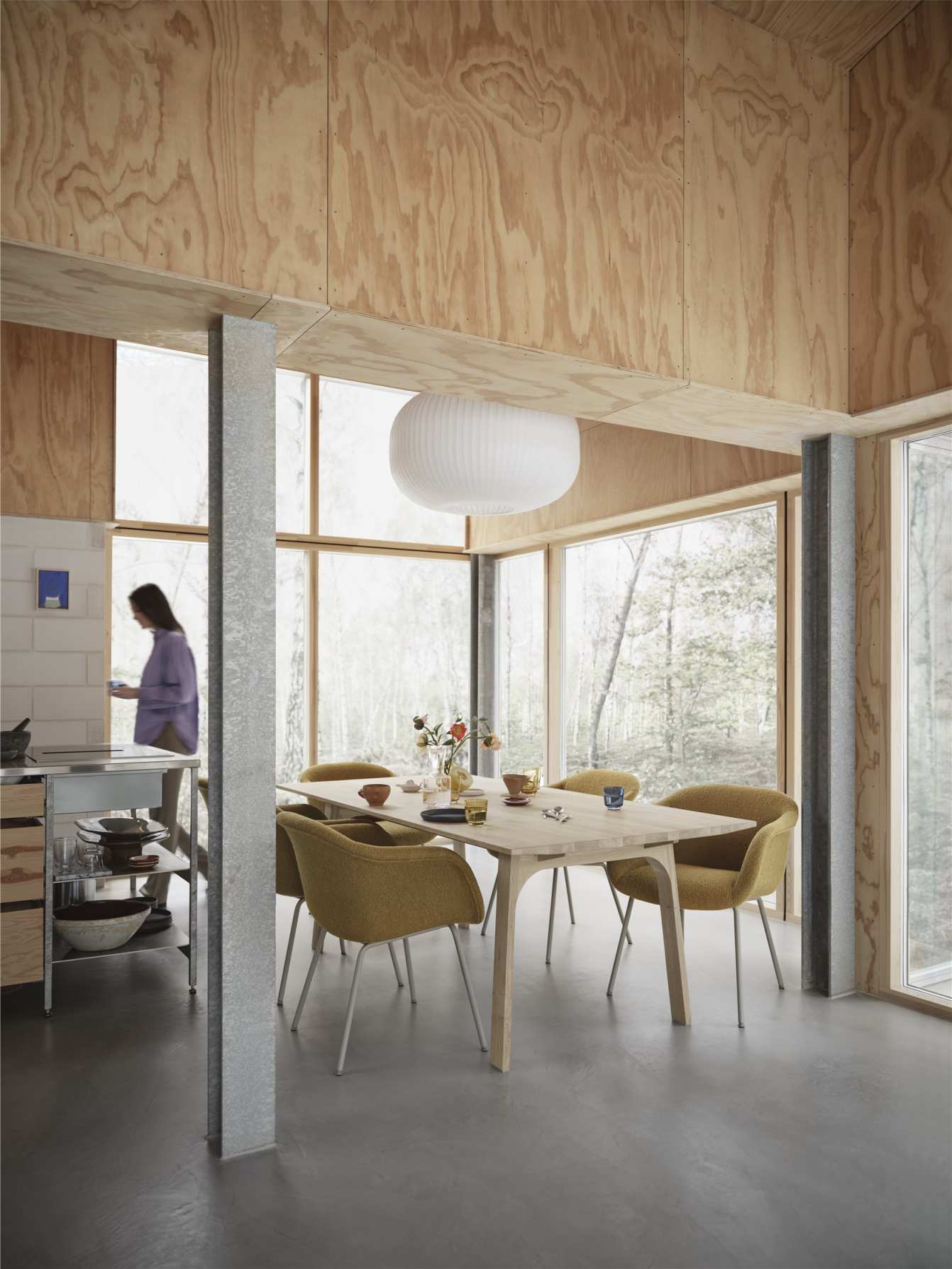 Heller Raum mit Earnest Esstisch von Muuto, ausziehbar, mit gelben Stühlen und Dekoration.