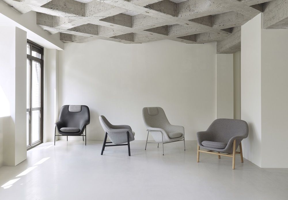 Graue Normann Copenhagen Lounge Sessel in verschiedenen Ausführungen in einem hellen Raum.