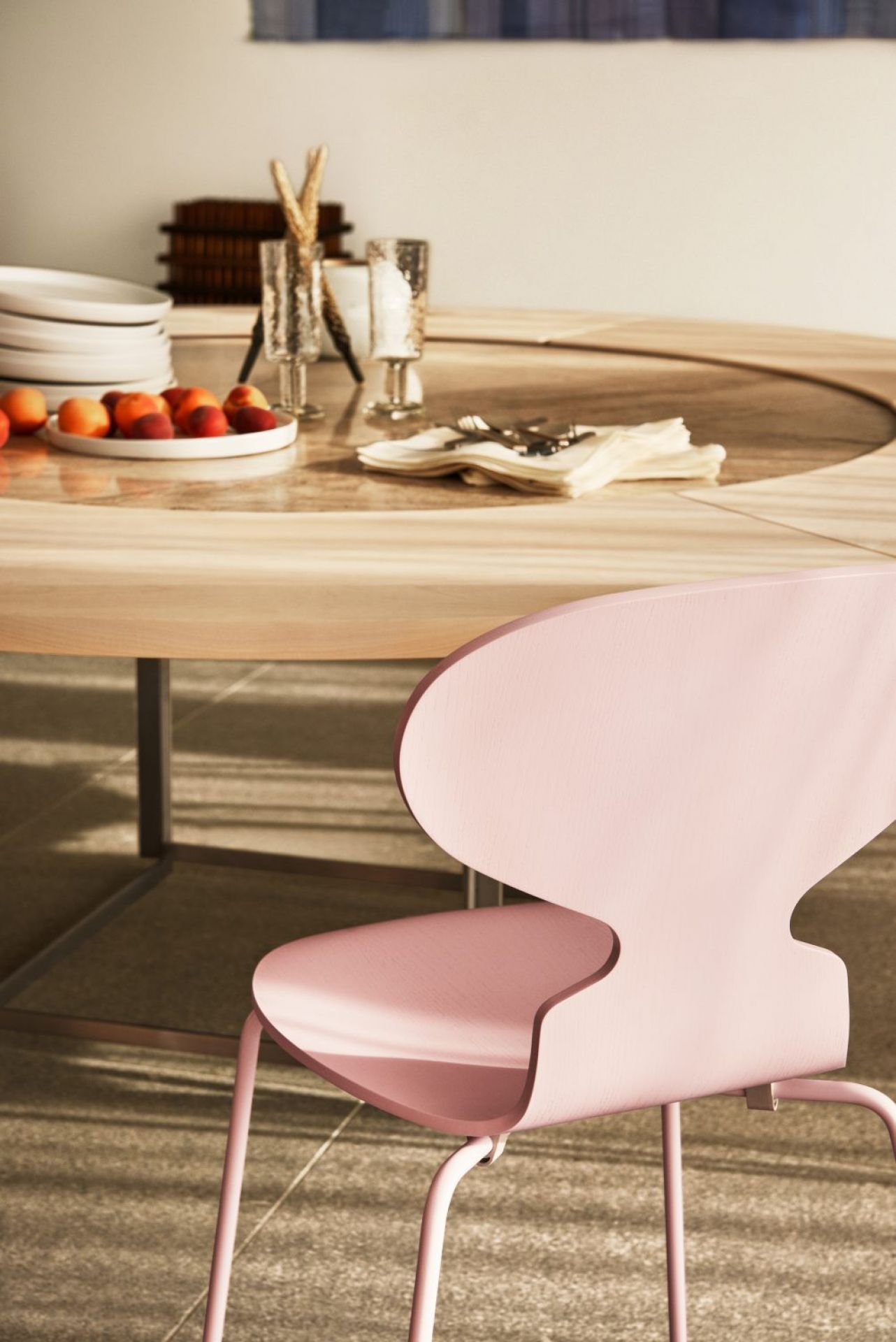 PK54 Esstisch von Fritz Hansen mit rosa Stuhl, Geschirr und Dekoration für ein stilvolles Esszimmer.