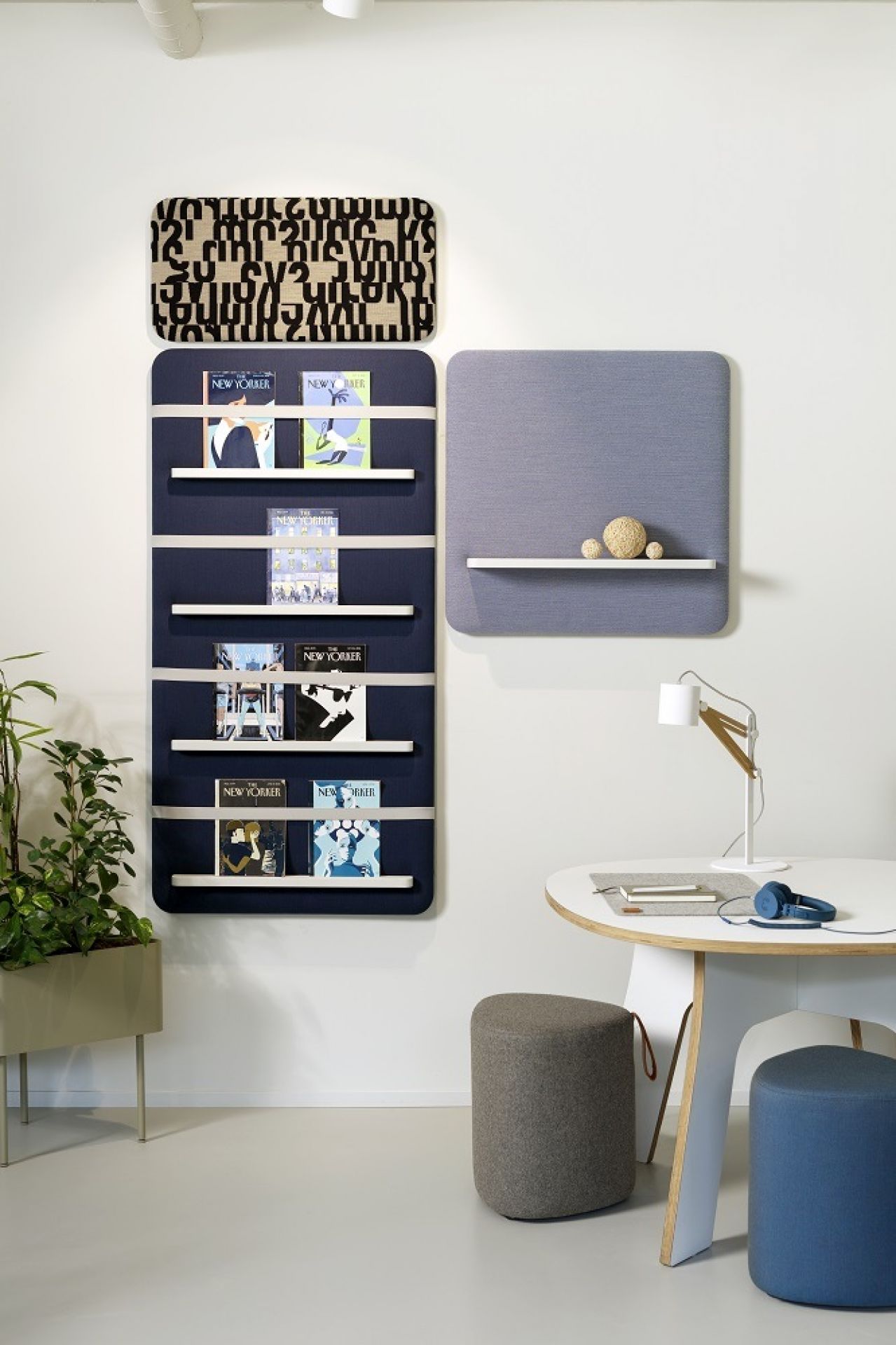 Cascando Pillow Wall Pinnwand-Set im Büro: Blaue Wandpaneele mit Regalen, Tisch, Lampe und Hockern.