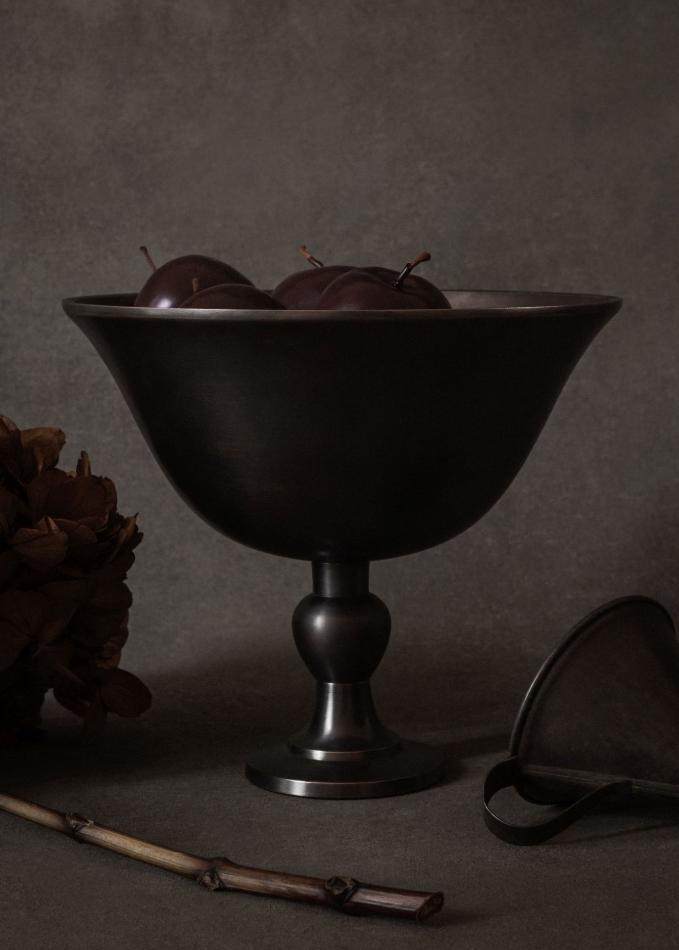 Elegante Audo Copenhagen Schale, Pavot Schale, aus dunklem Metall mit Pflaumen gefüllt, Tischdekoration.