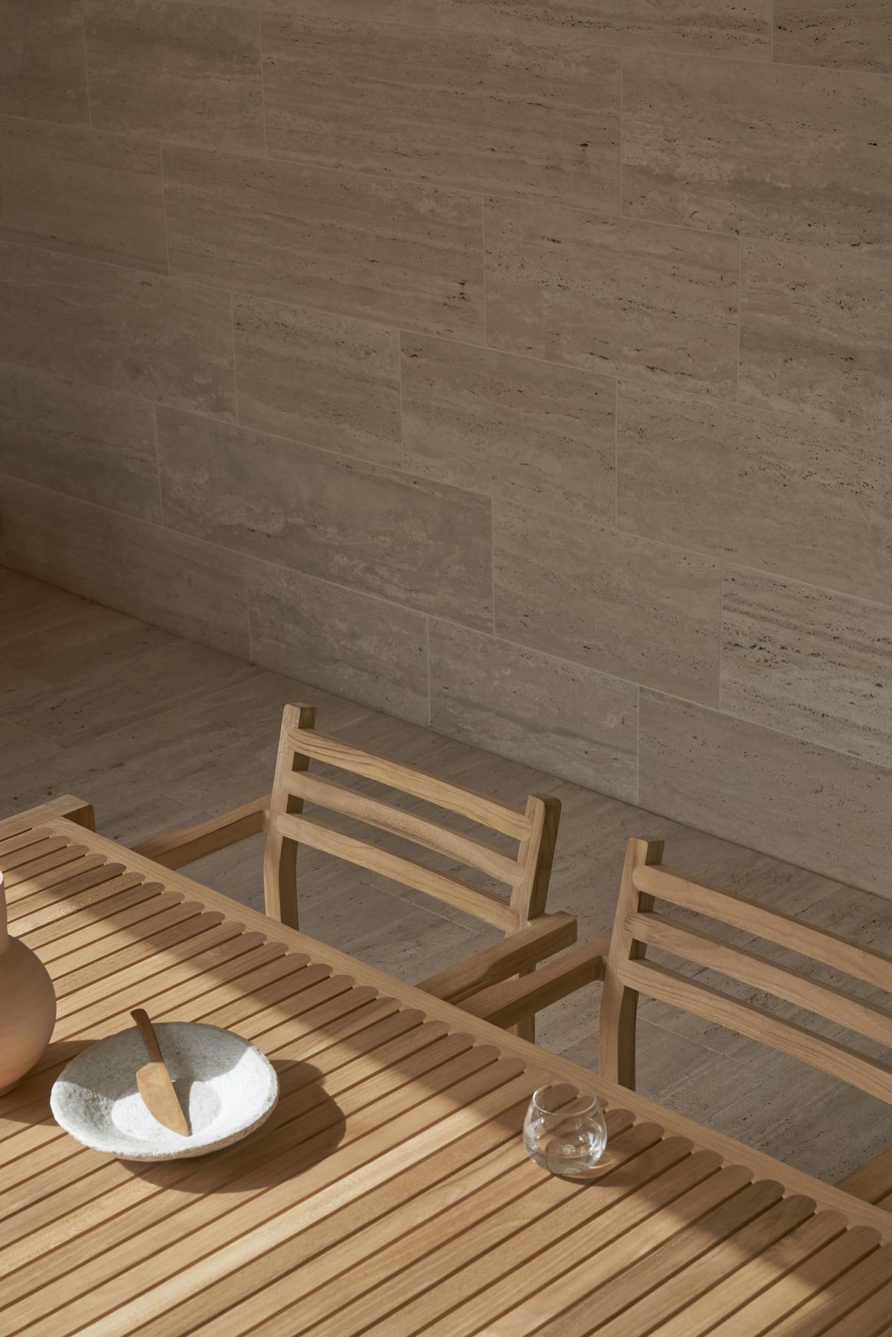 Nahaufnahme von Carl Hansen AH502 Teak Armlehnstuhl und Gartentisch mit Geschirr für den Außenbereich.