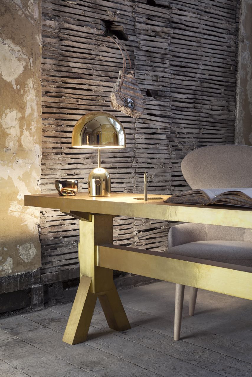 Goldene Bell Tischleuchte von Tom Dixon auf einem goldenen Schreibtisch in einem stilvollen Interieur.