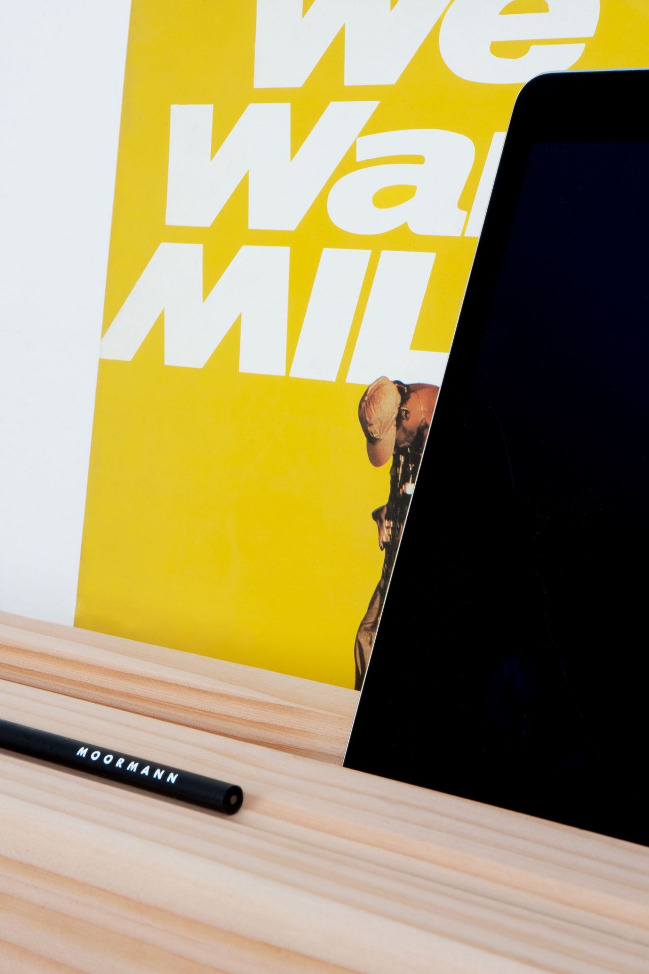 Detailaufnahme des Moormann Kurt Sekretärs mit Laptop, Stift und gelbem Poster im Hintergrund.