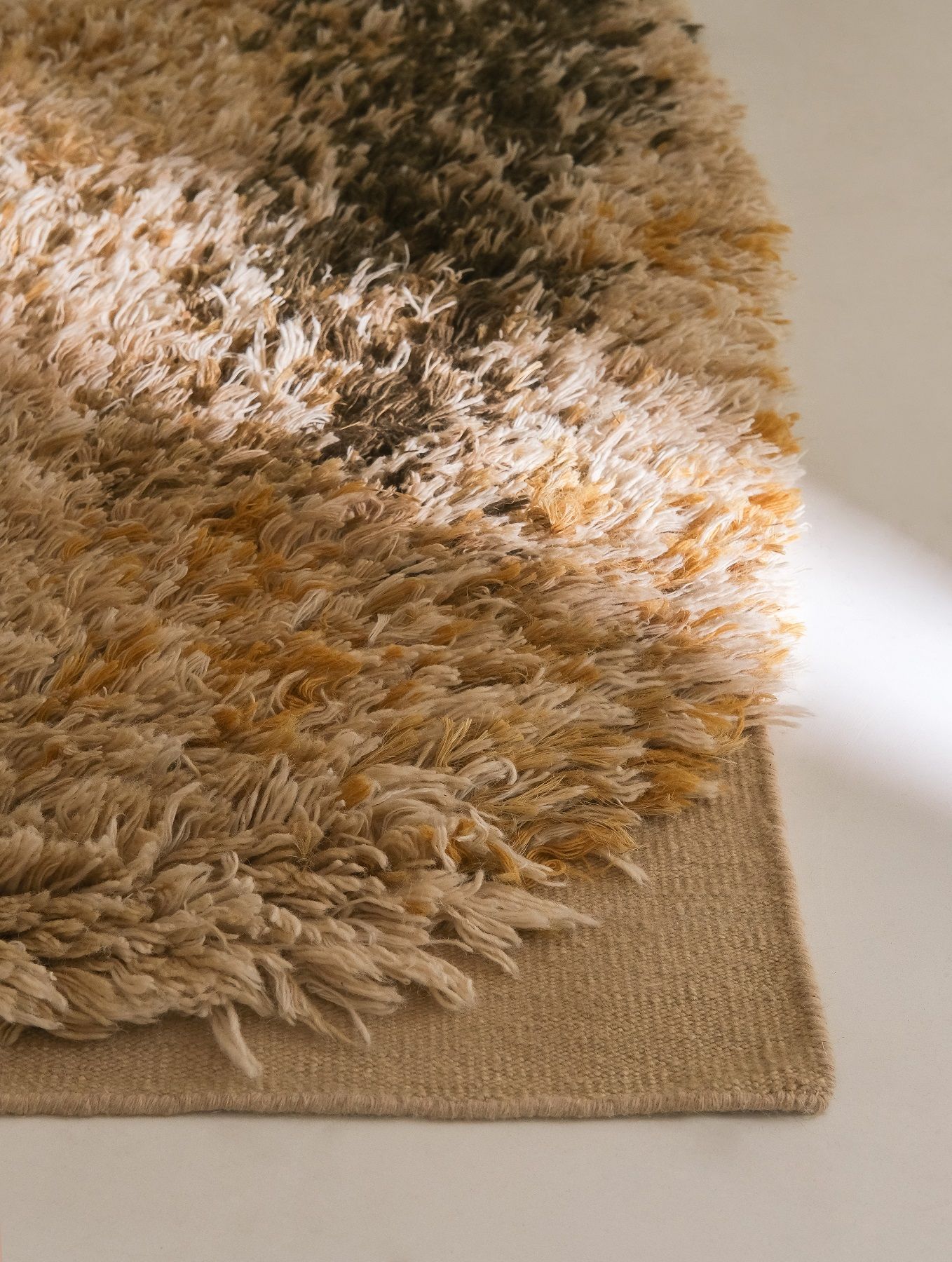 Detailaufnahme des Nanimarquina Alga Rug Teppichs in Beige, Braun und Gelb mit Fransen.