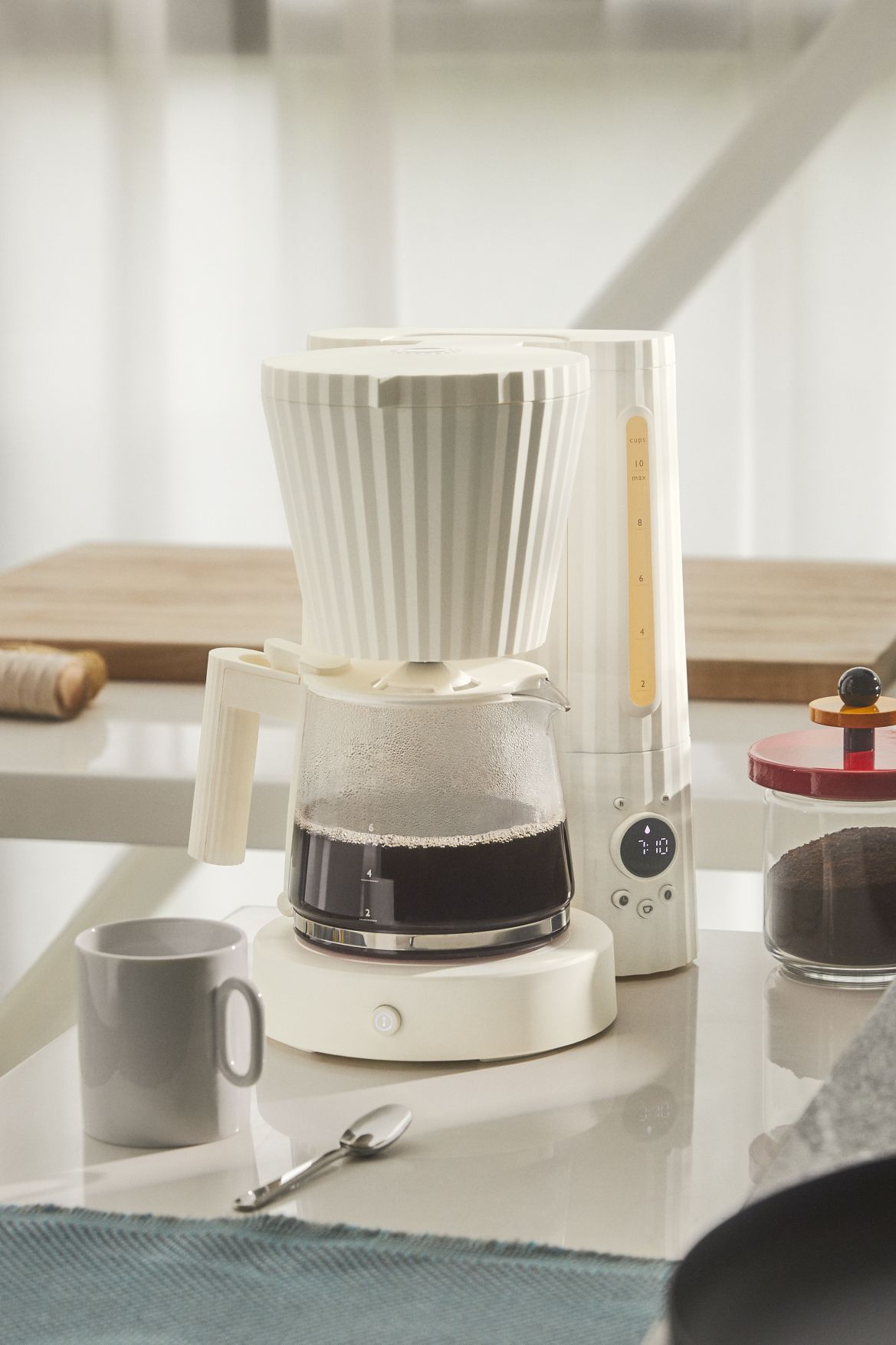 MDL14 Plissé Filterkaffeemaschine von Alessi: Elegante, cremefarbene Kaffeemaschine mit Glaskanne und Plissee-Design.