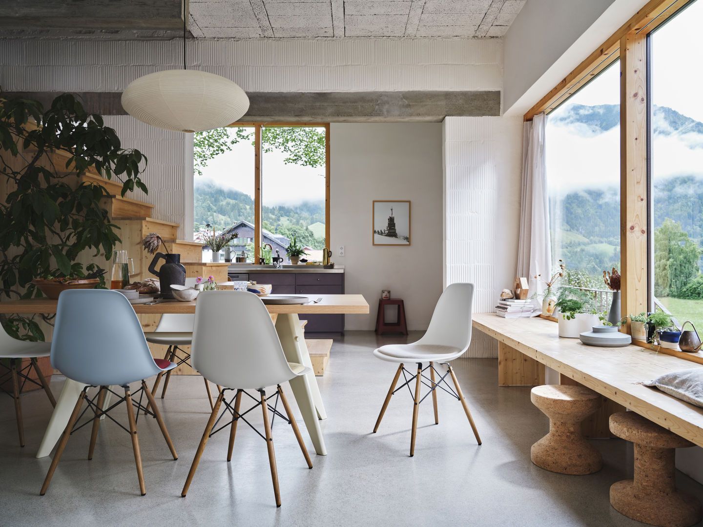 Esszimmer mit Eames DSW Stühlen von Vitra, verschiedene Farben, Sitzpolster, Holzbeine, moderner skandinavischer Einrichtungsstil.
