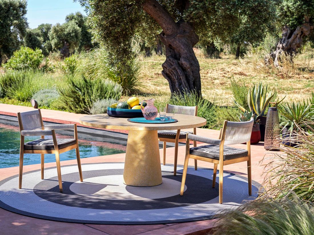 Cassina Dine Out Tisch mit Terrazzo-Platte und Stühlen im Garten am Pool.