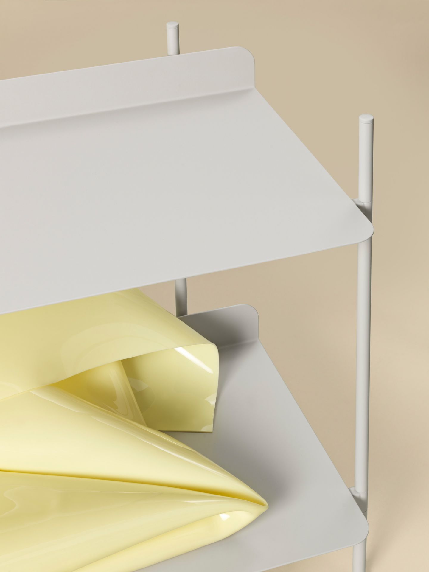 Detailaufnahme des Muuto Compile Regalsystems in Weiß mit gelbem Dekoelement.