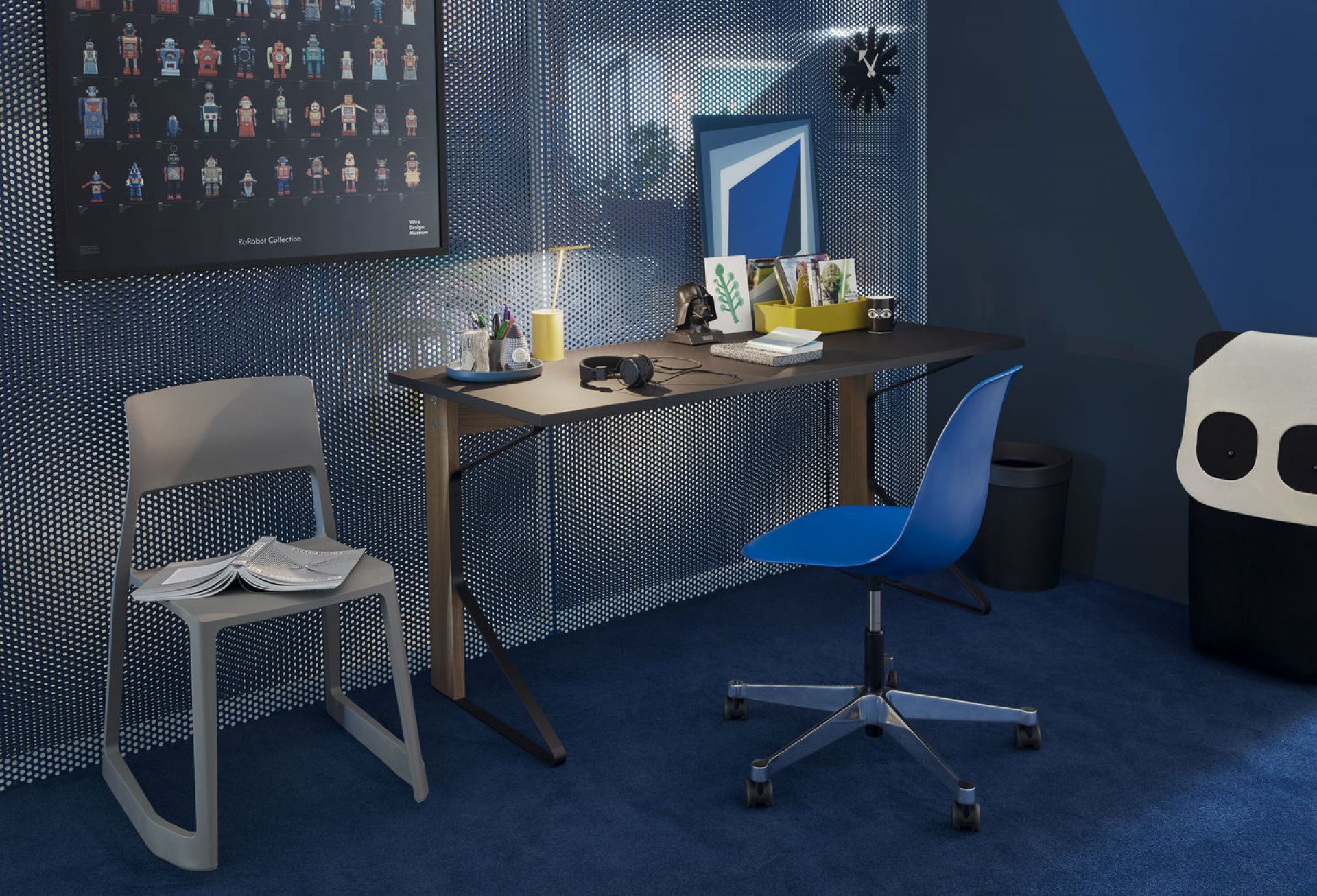 Blauer Eames Plastic Side Chair PSCC Drehstuhl von Vitra am Schreibtisch im modernen Büro.