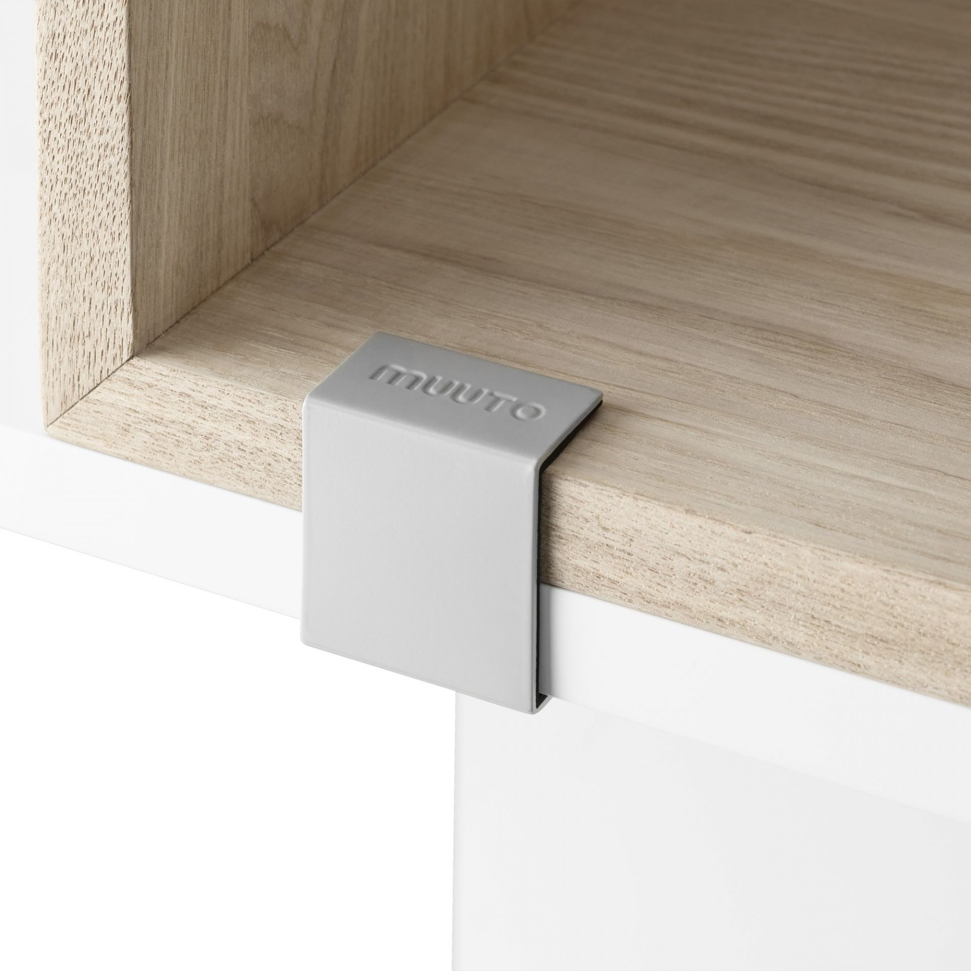 Detailaufnahme des Muuto Stacked Storage System 2.0 Regalsystems, das ein helles Holzregal mit grauem Verbindungsstück zeigt.