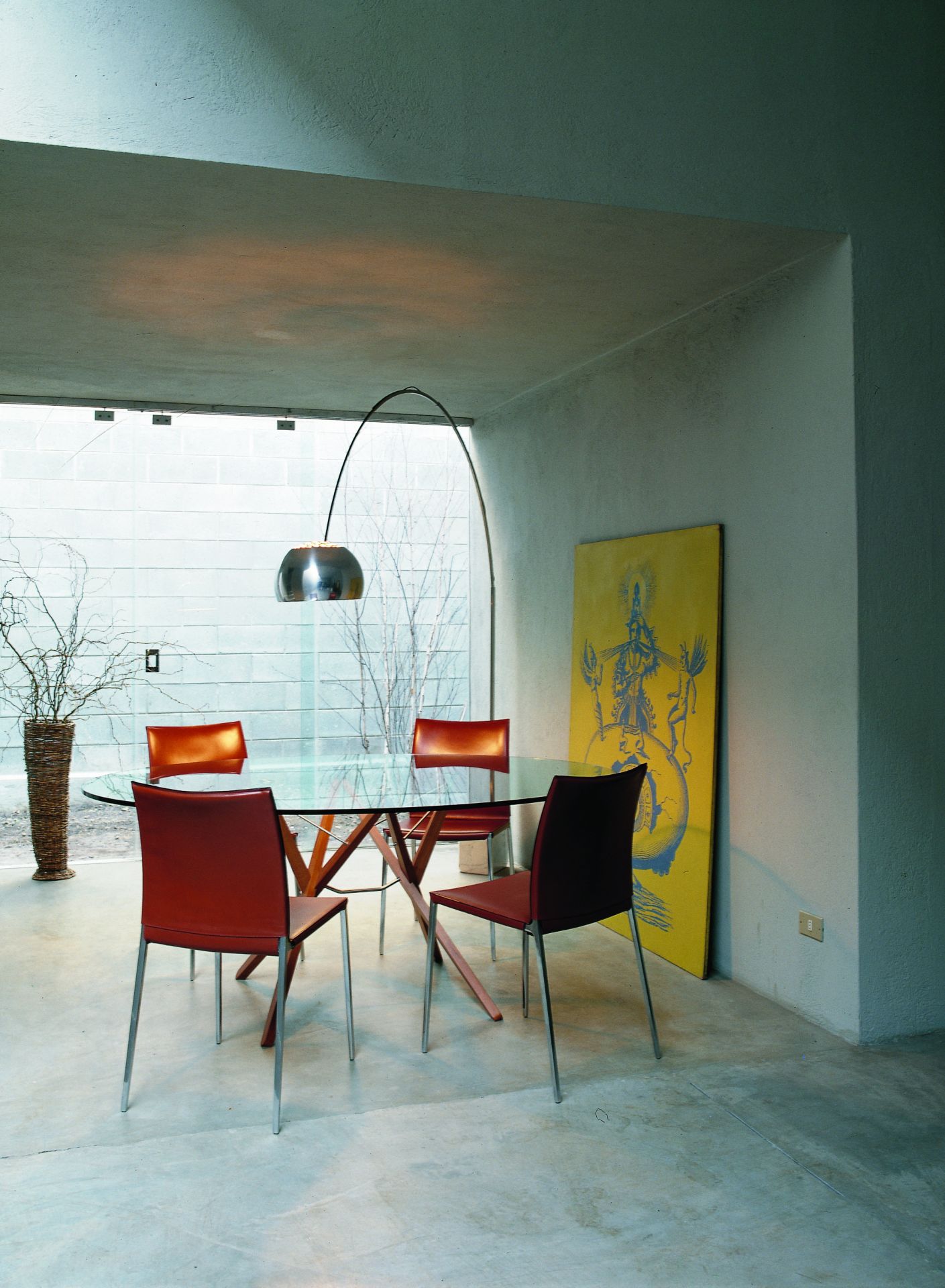 Esszimmer mit Glas Esstisch und vier roten Lia Stühlen ohne Armlehnen von Zanotta, modernes Möbeldesign.