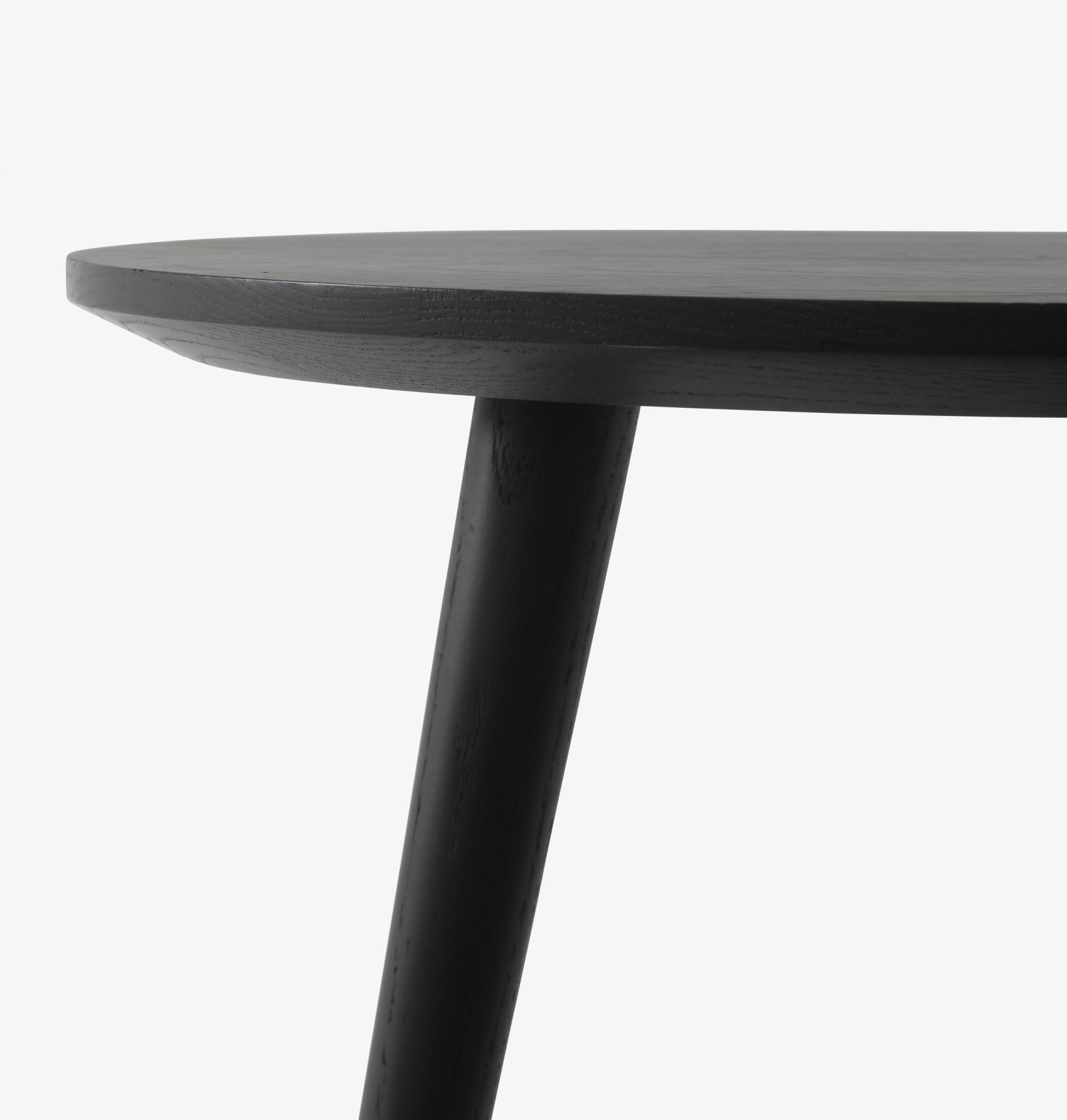 Detailaufnahme des AndTradition In Between Table SK3/SK4 Tisches mit runder, schwarzer Tischplatte und einem Tischbein.