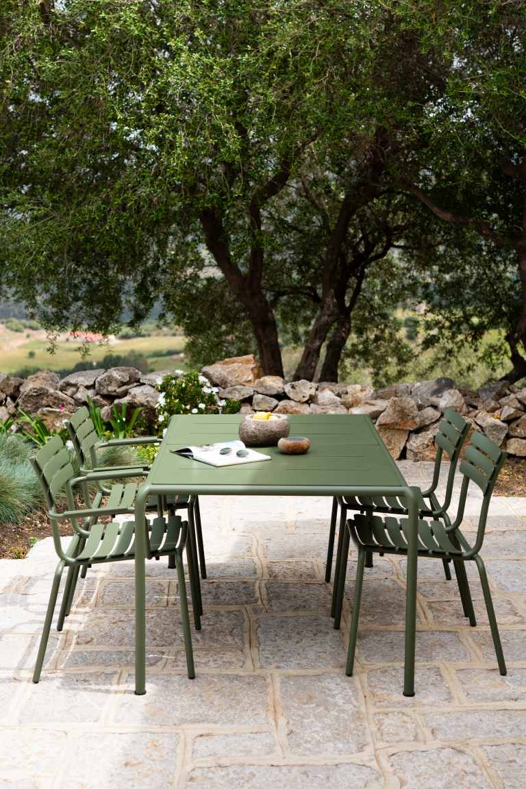 Alua Armrest Dining Chair von Houe, grünes Gartenmöbel-Set mit Tisch und Stühlen im Freien.