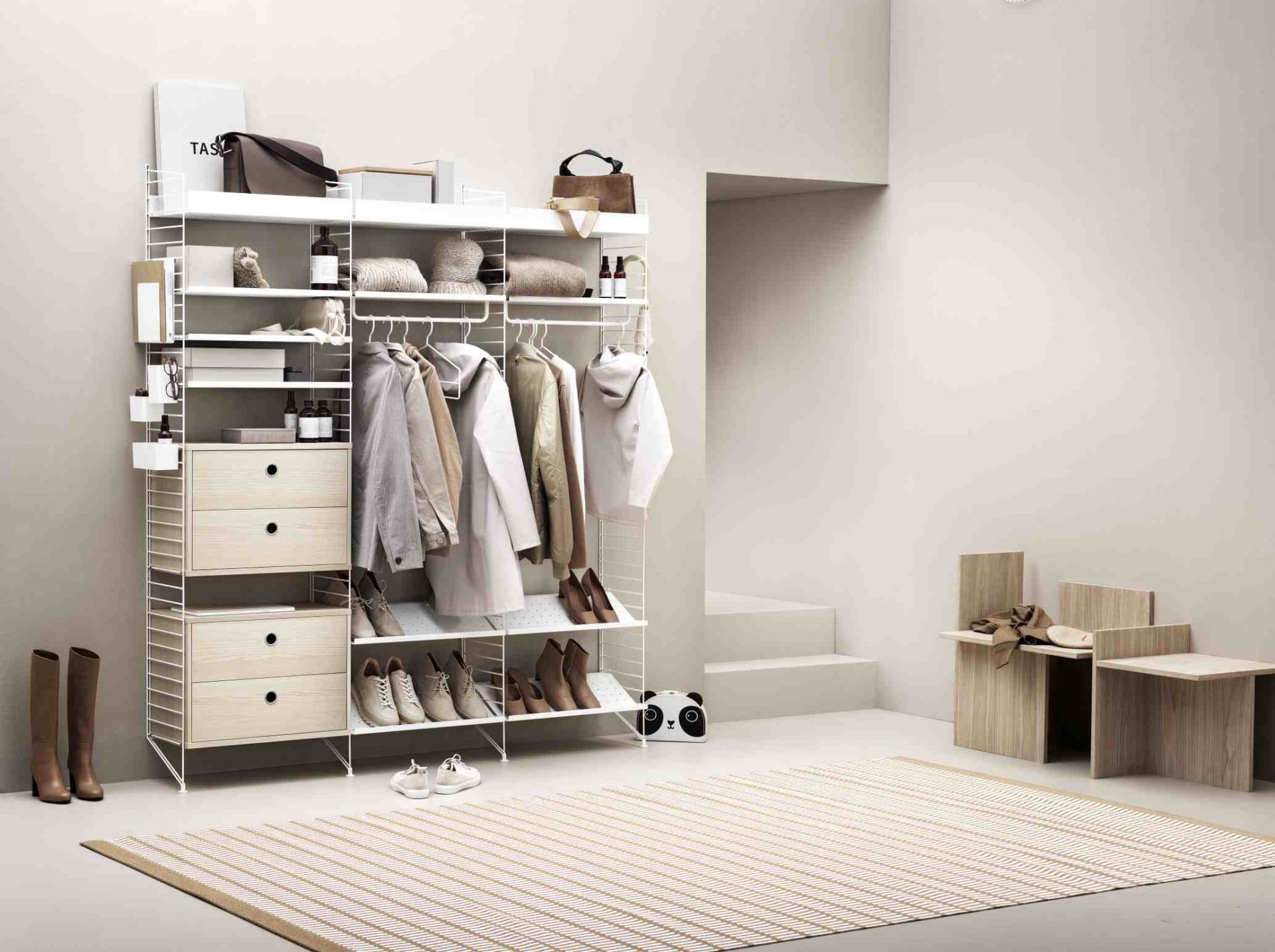 Beige String Regalsystem im Schlafzimmer mit Kleidung, Schuhen und Accessoires, modernes skandinavisches Design.