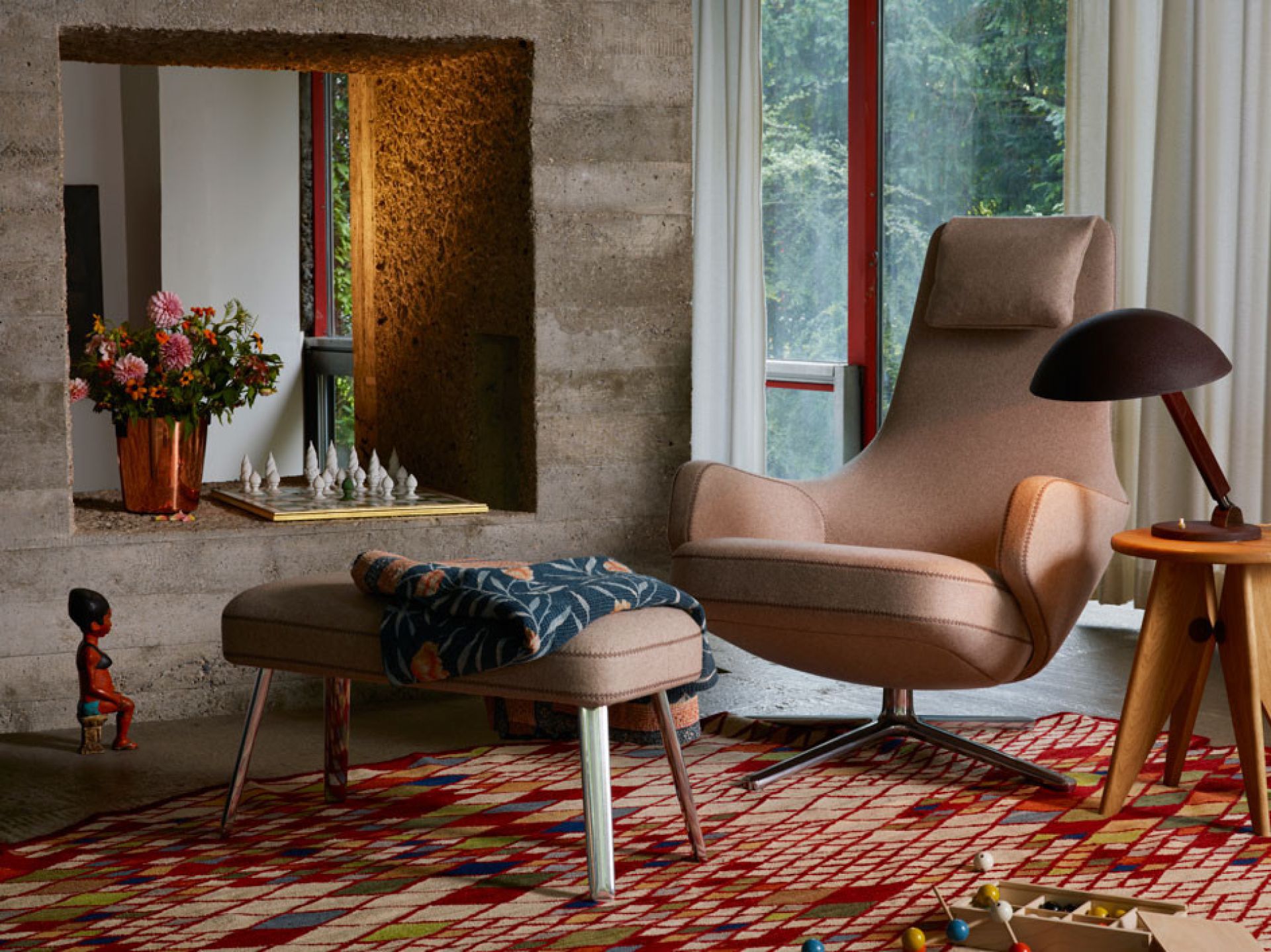 Beiger Repos Sessel mit Ottoman von Vitra in stilvollem Wohnzimmer mit Teppich.