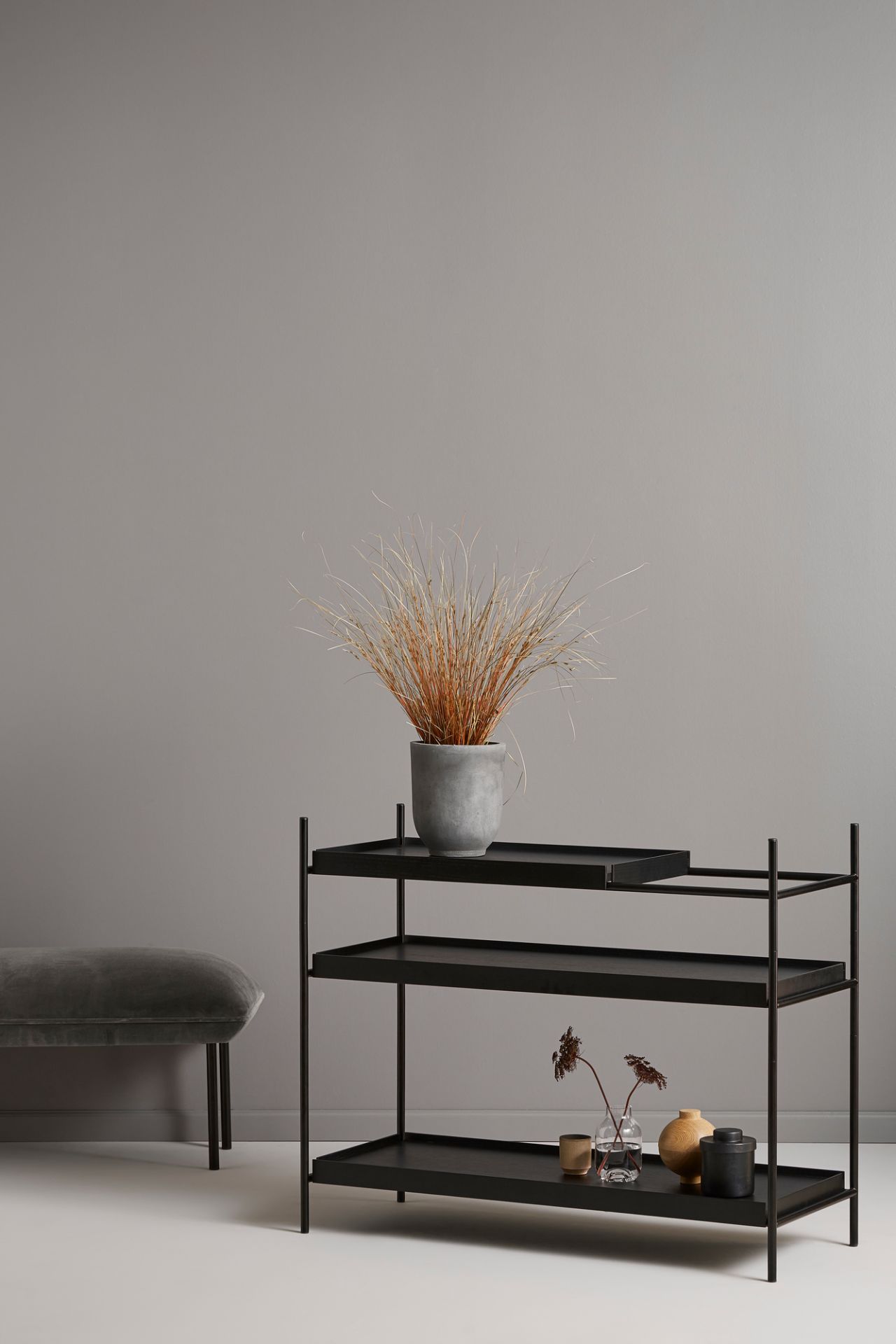 Schwarzes Tray Shelf Low Regal von Woud mit drei Ablagen, dekoriert mit Pflanzen und Vasen.