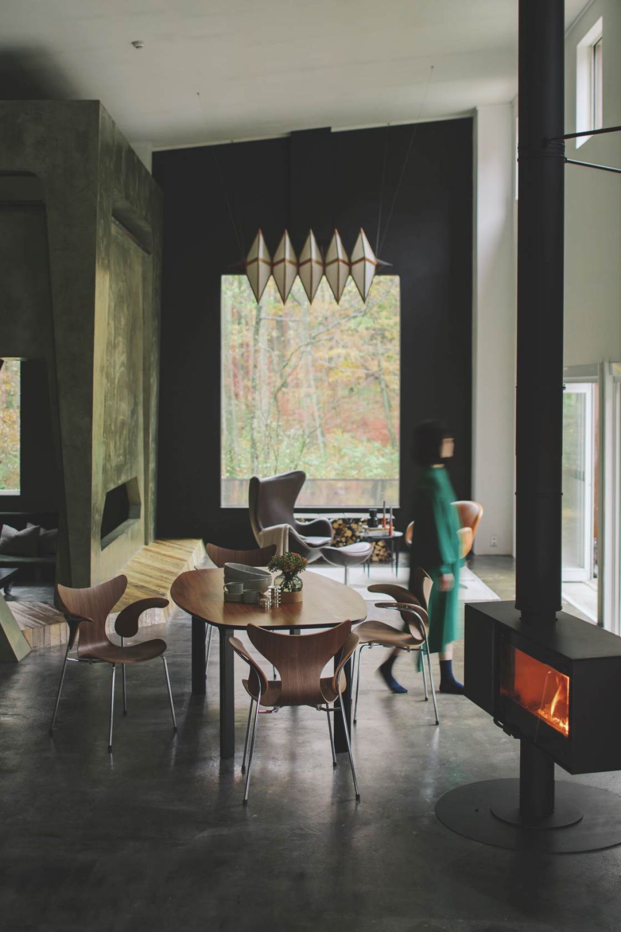 Fritz Hansen Lily Armlehnenstuhl 3208 aus Holz und Stahl im modernen Esszimmer mit Kamin.