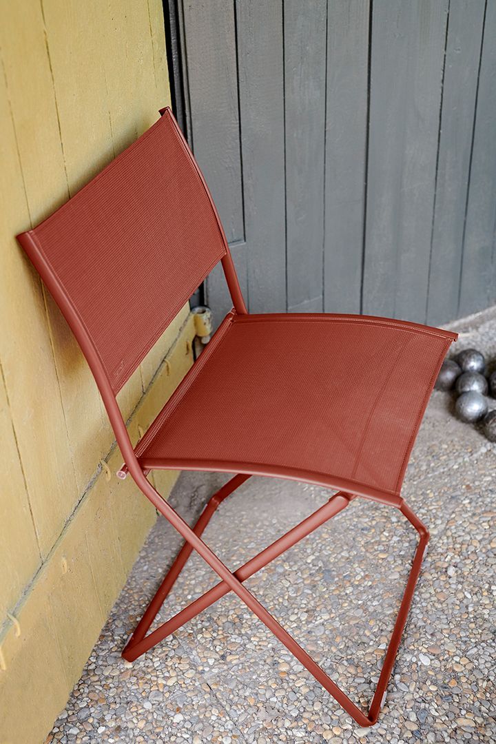 Nahaufnahme eines roten Fermob Plein Air Stuhls für den Außenbereich, ideal für Garten und Terrasse.