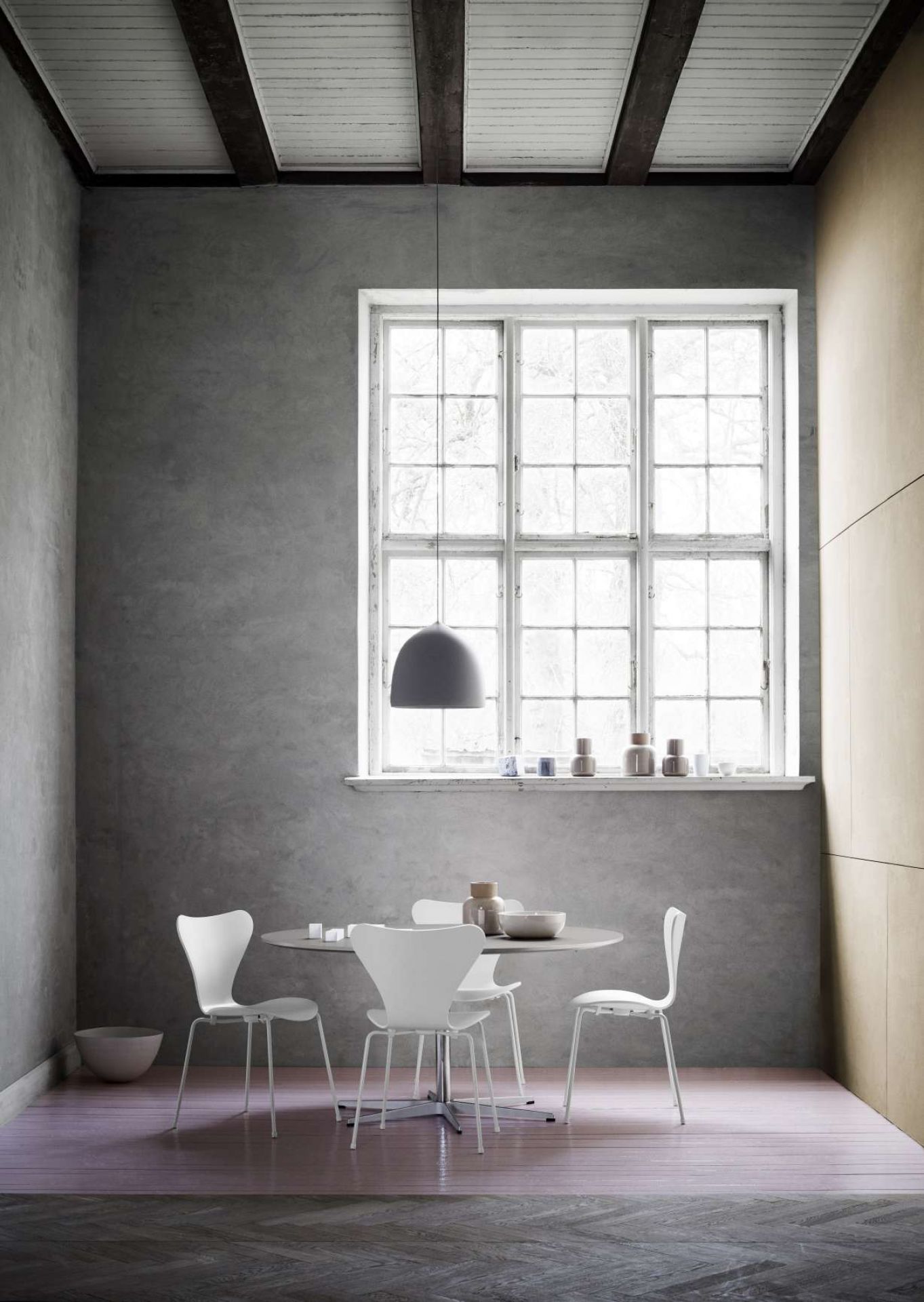 Zirkular Tisch von Fritz Hansen, runder Esstisch mit weißen Stühlen in modernem Interieur.