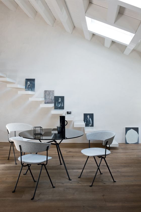 Magis Officina Stühle in Grau um einen schwarzen Esstisch in modernem Interieur.