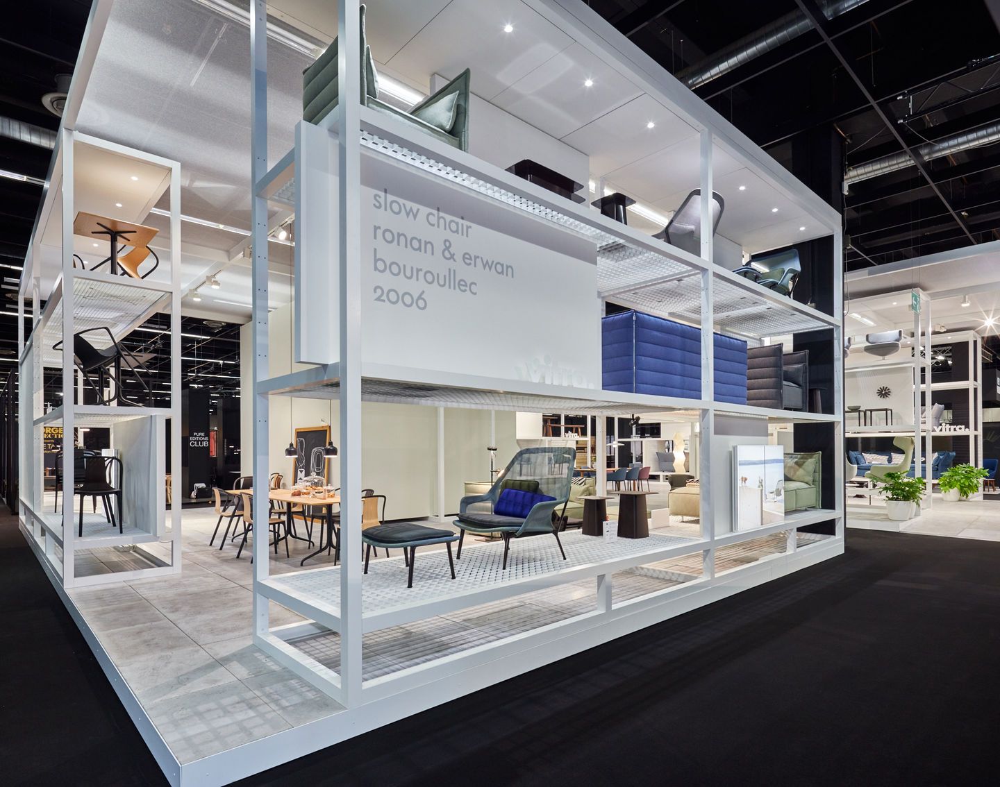 Ausstellungsstand mit Vitra Slow Chair Sessel und Ottoman in verschiedenen Farben und Designs.