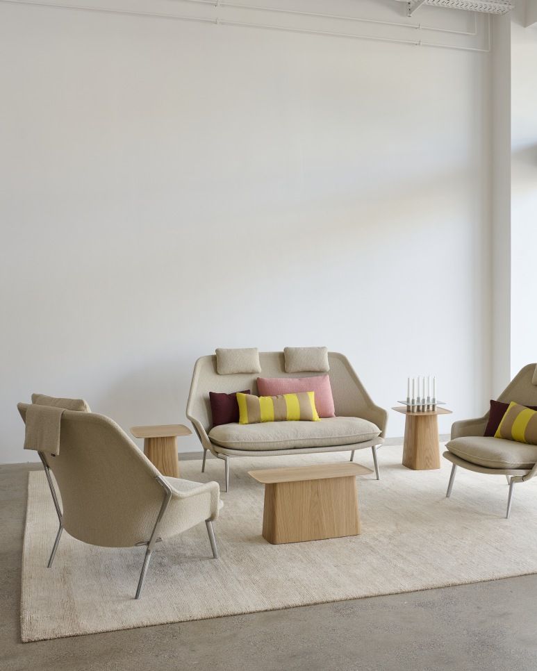 Vitra Slow Sofa und Sessel aus Stoff in Beige mit Holztischen und Teppich.