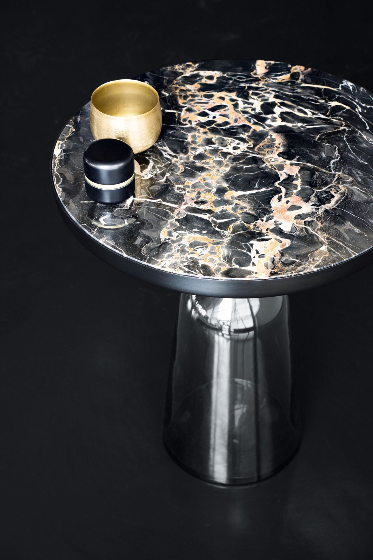 Nahaufnahme der ClassiCon Bell Coffee Table Tischplatte aus schwarzem Marmor mit goldener und schwarzer Dekoration.