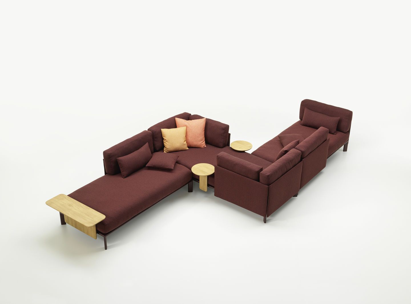 Anagram Sofa Plattform 90 x 180 cm von Vitra in Weinrot mit Kissen und Holztischen.