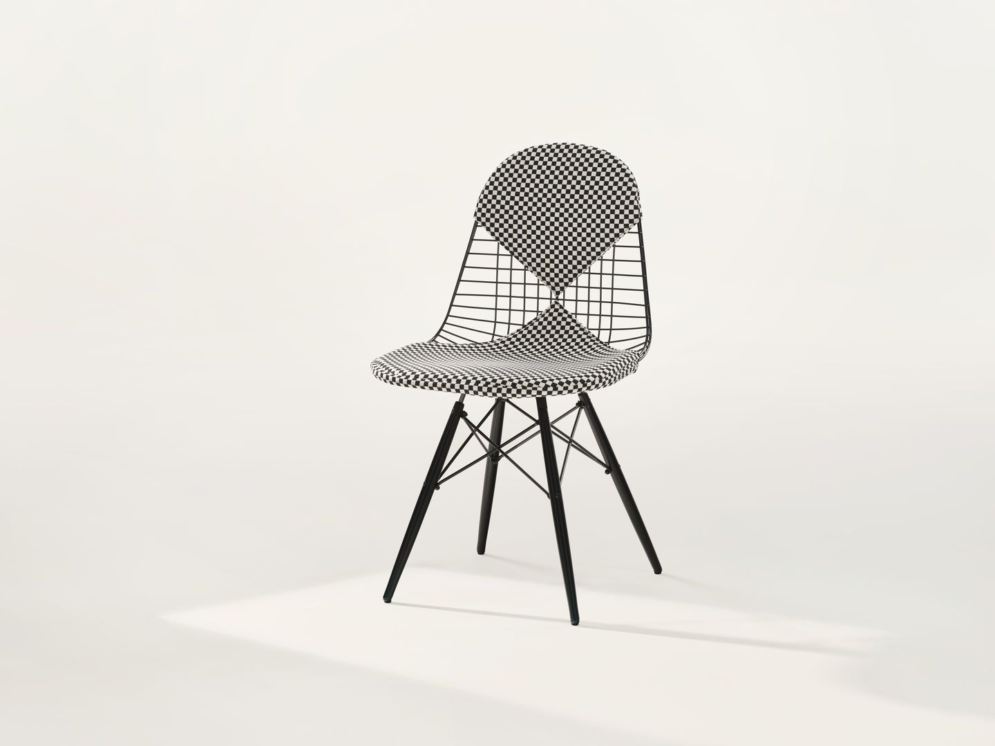 Vitra DKW-2 Wire Chair Stuhl mit schwarz-weiß kariertem Sitzpolster und Rückenlehne auf weißem Hintergrund.