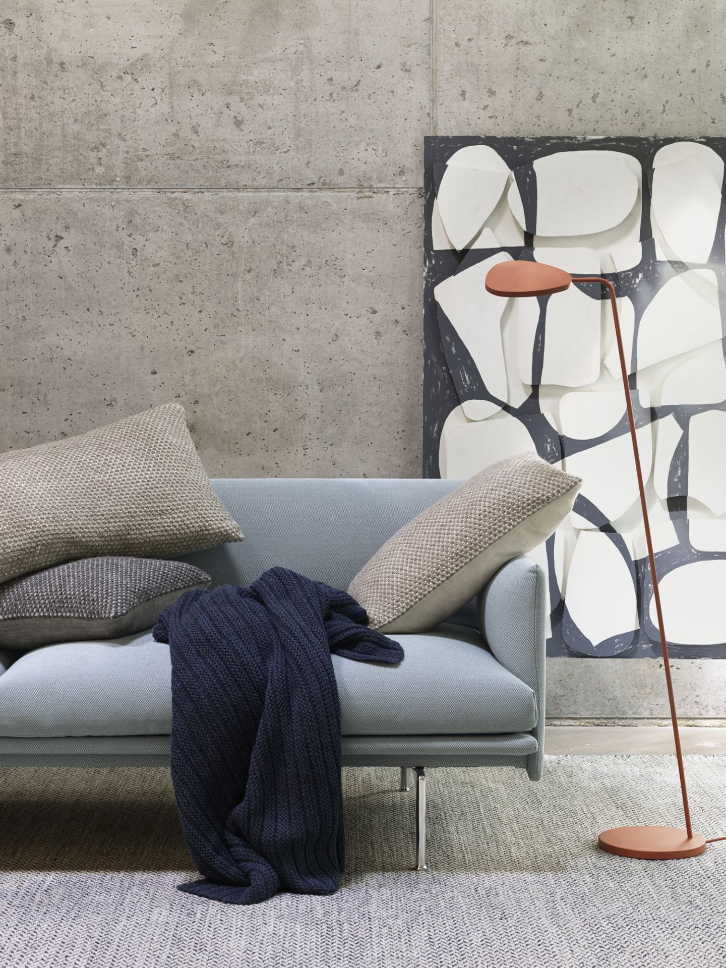 Muuto Leaf Stehleuchte in Kupfer neben Sofa und Kunstwerk im Wohnzimmer.