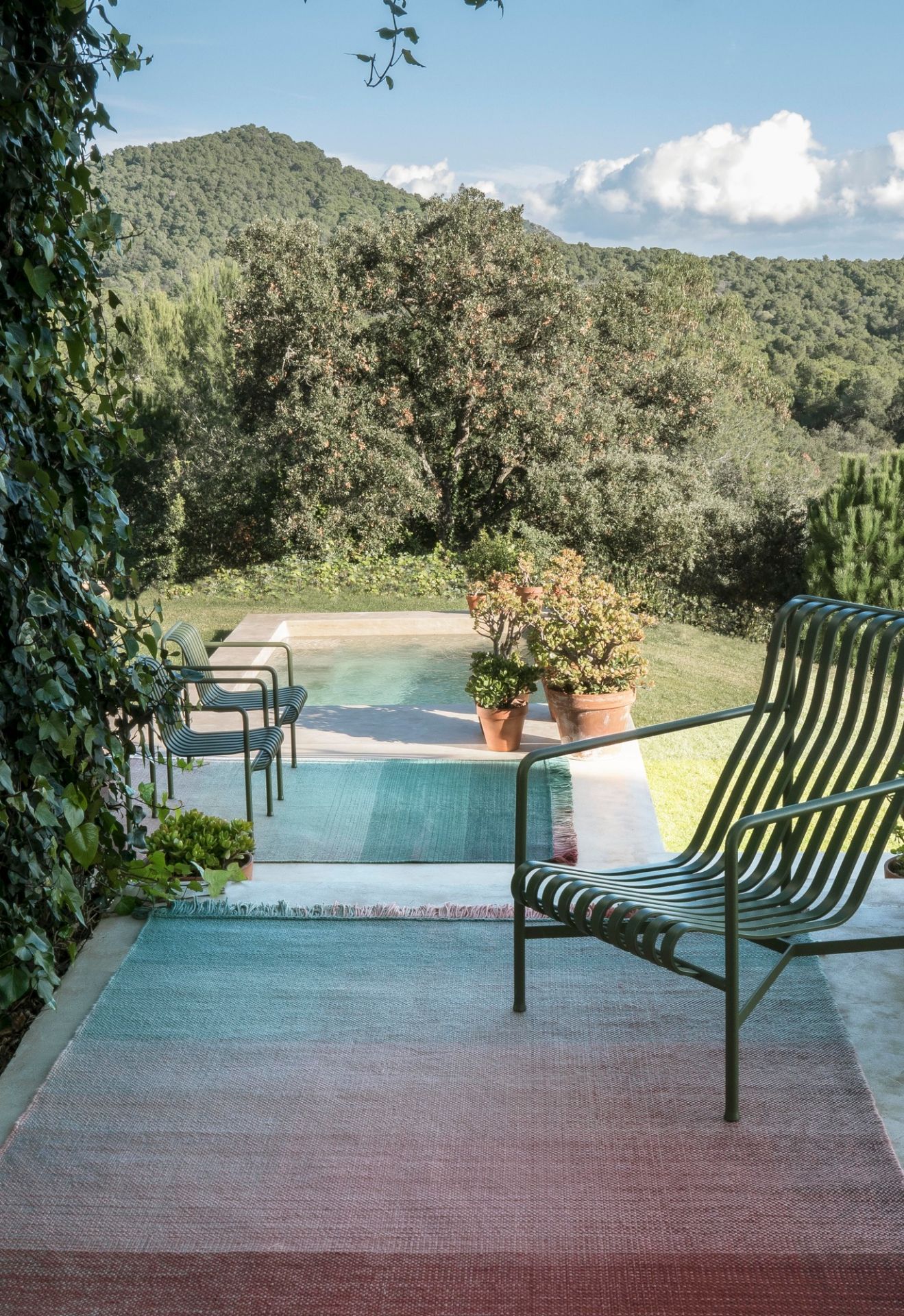 Nanimarquina Shade Outdoor Teppich, Palette 4, 170x240 cm, auf einer Terrasse mit Pool.