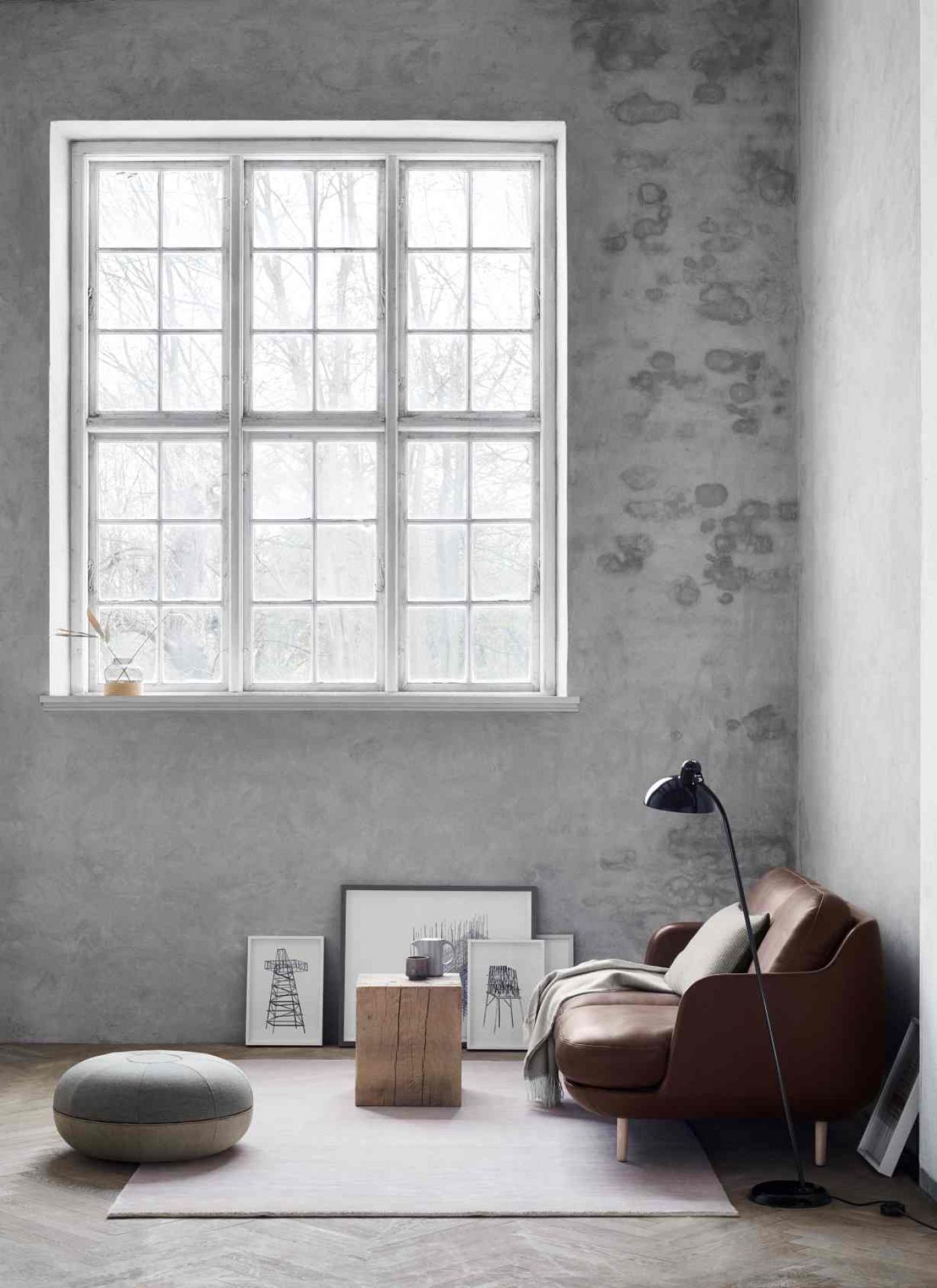 Braunes Fritz Hansen Lune Sofa in modernem Wohnzimmer mit Fenster und Betonwand.