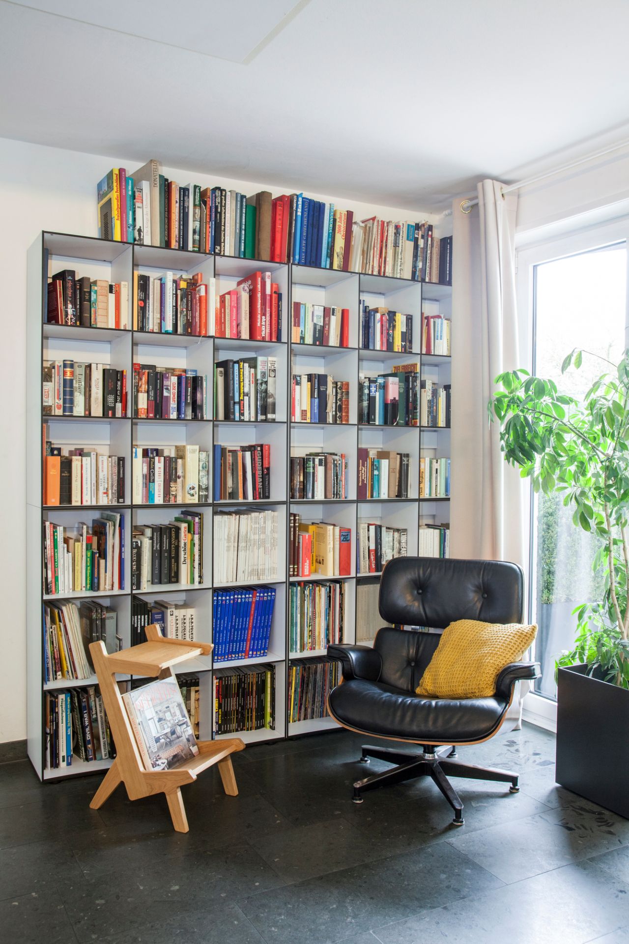 Helles Wohnzimmer mit großem Library HP 3x3 Modul Regal von Hans Hansen, gefüllt mit Büchern.
