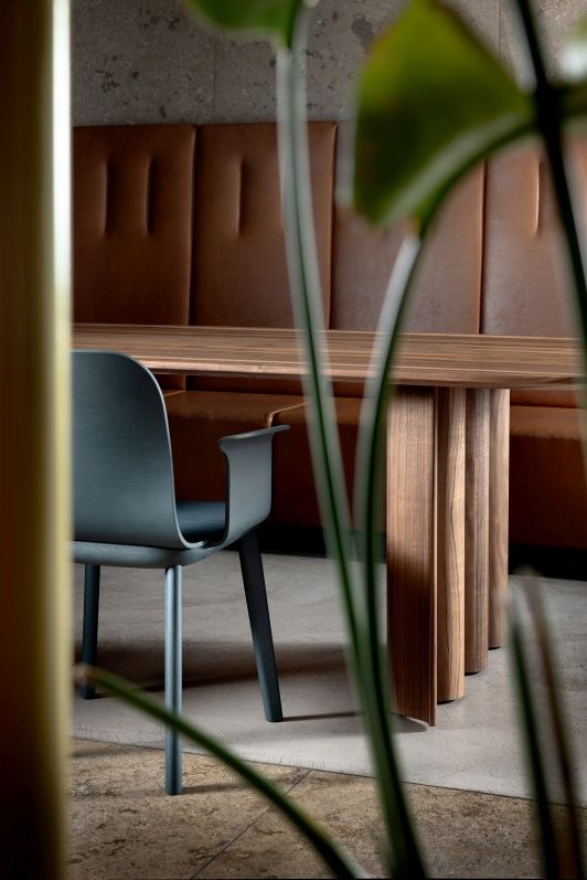 Aeon Comfort Chair Armlehnstuhl von Zeitraum, grauer Design-Stuhl mit Armlehnen an Holztisch, moderne Innenarchitektur.