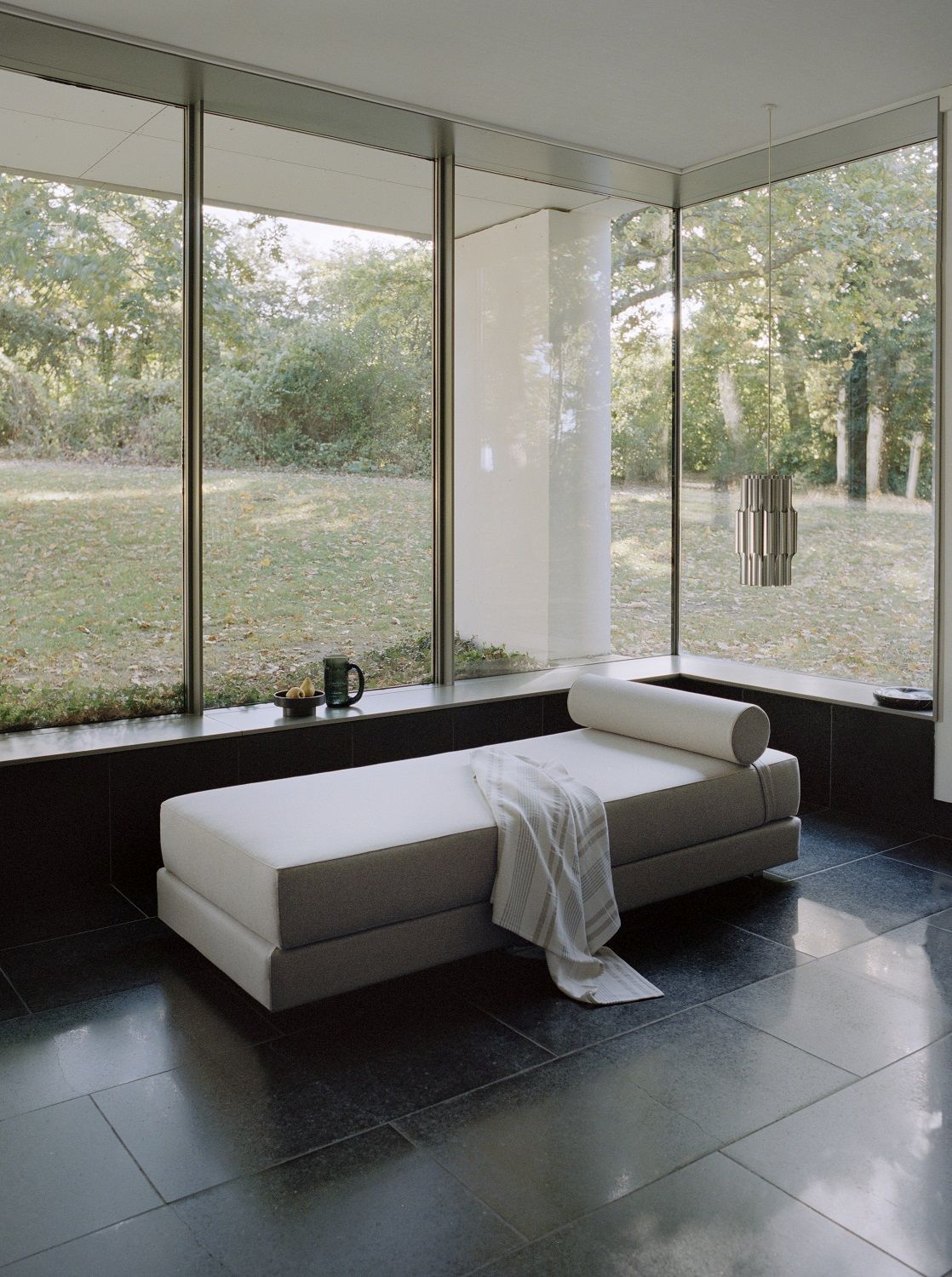 Lubi Daybed Schlafsofa mit Taschenfederkernmatratze in modernem Raum mit großem Fenster und Gartenblick.