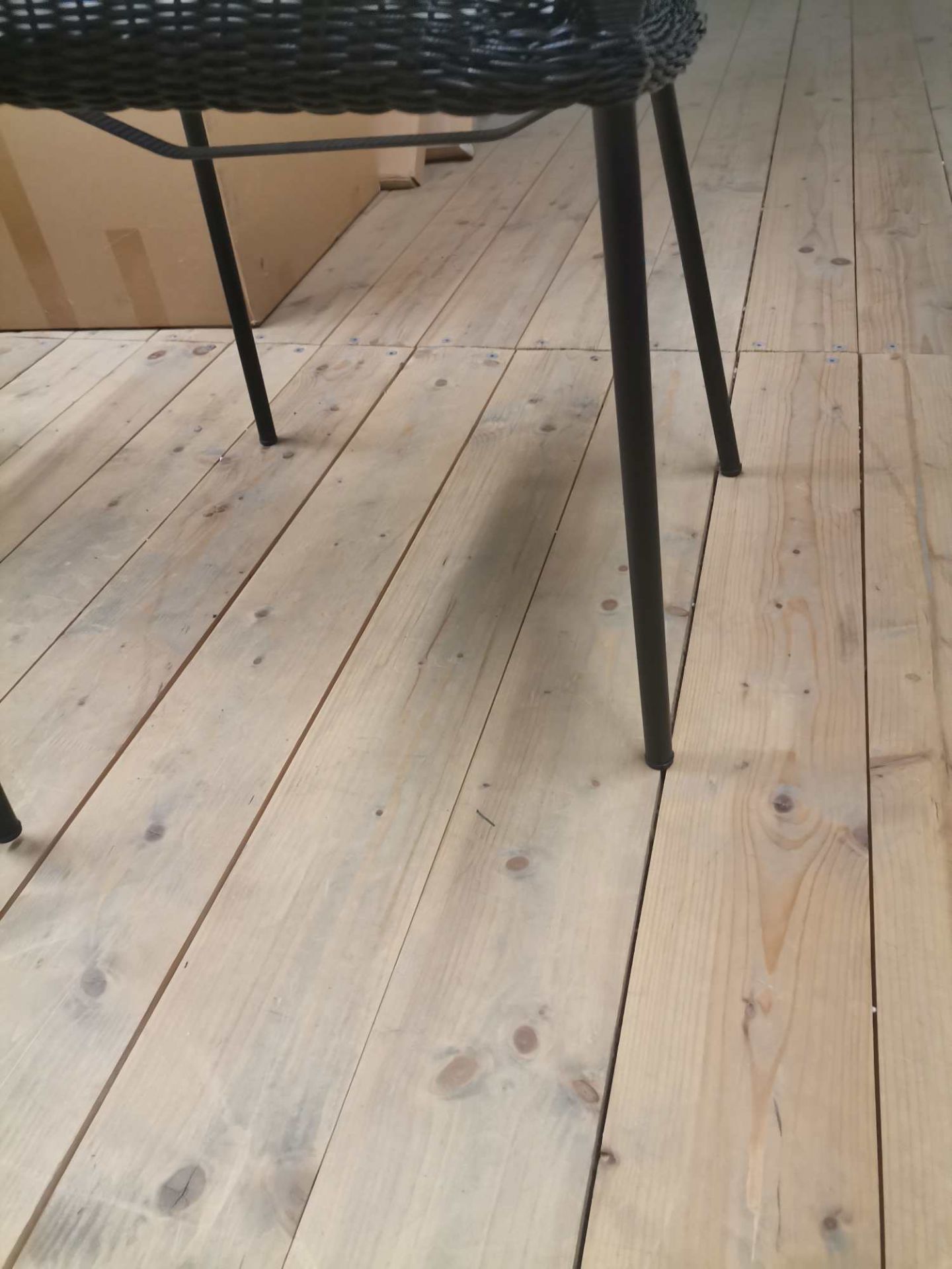 Detailaufnahme: Schwarzer Breeze Outdoor Stuhl mit Vierfußgestell auf hellem Holzboden. Gartenstuhl, Terrassenmöbel.