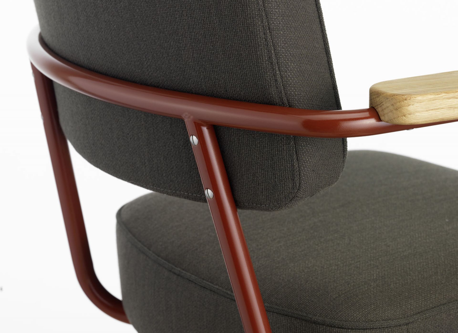 Detailaufnahme des Fauteuil Direction Pivotant Bürodrehstuhls von Vitra mit braunem Metallrahmen, grauer Polsterung und Holzarmlehne.