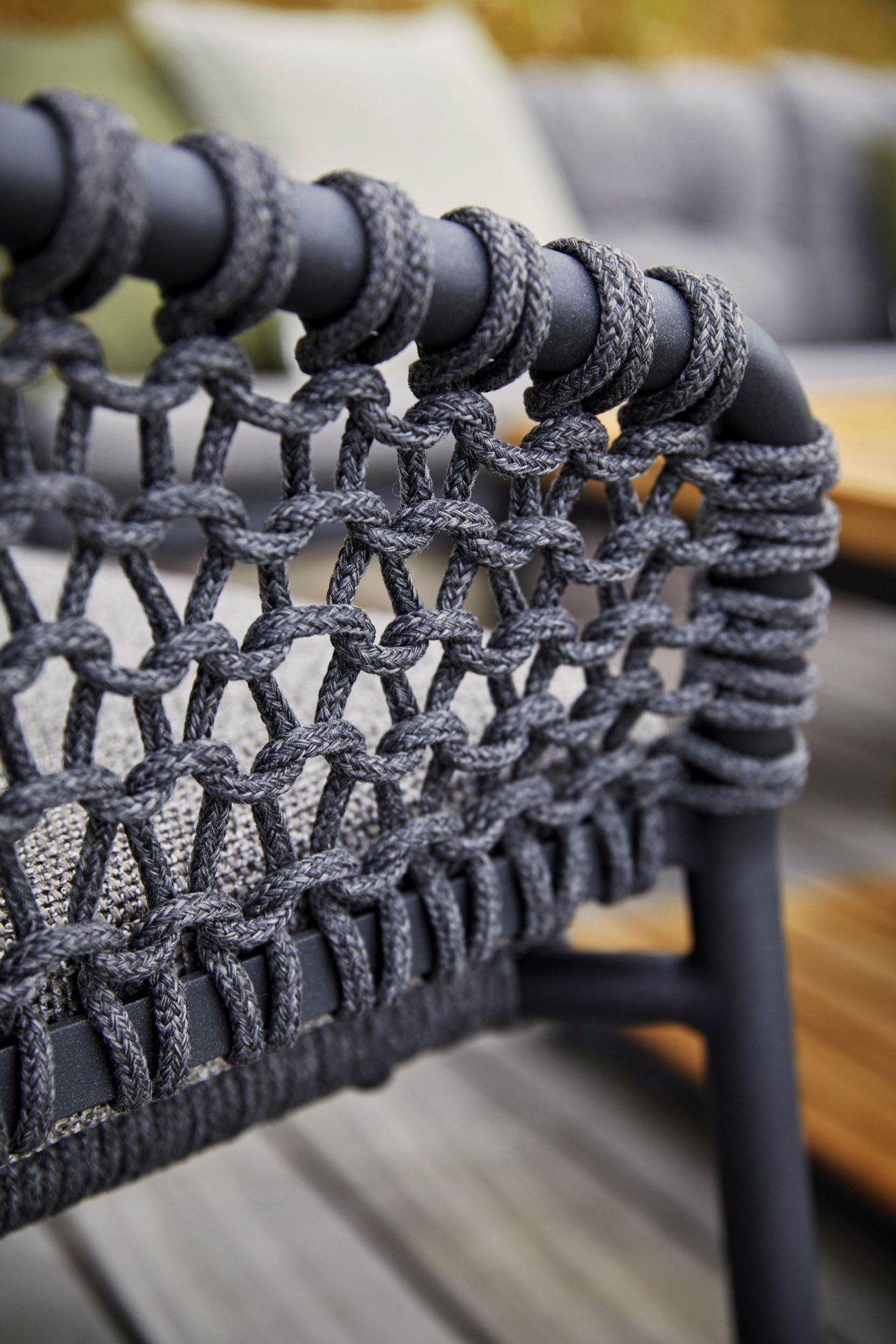 Detailaufnahme des Cane-Line Ocean Sofas: Dunkelgraues Geflecht und Rahmen eines Outdoor-Sofas.