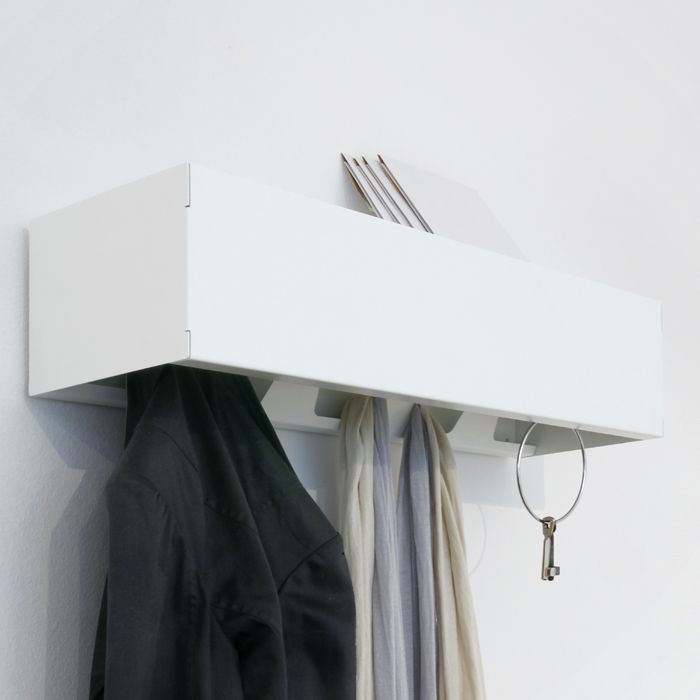 Weiße Wandgarderobe CR Linea1 mit Jacke, Schals und Schlüssel an der Wand befestigt.