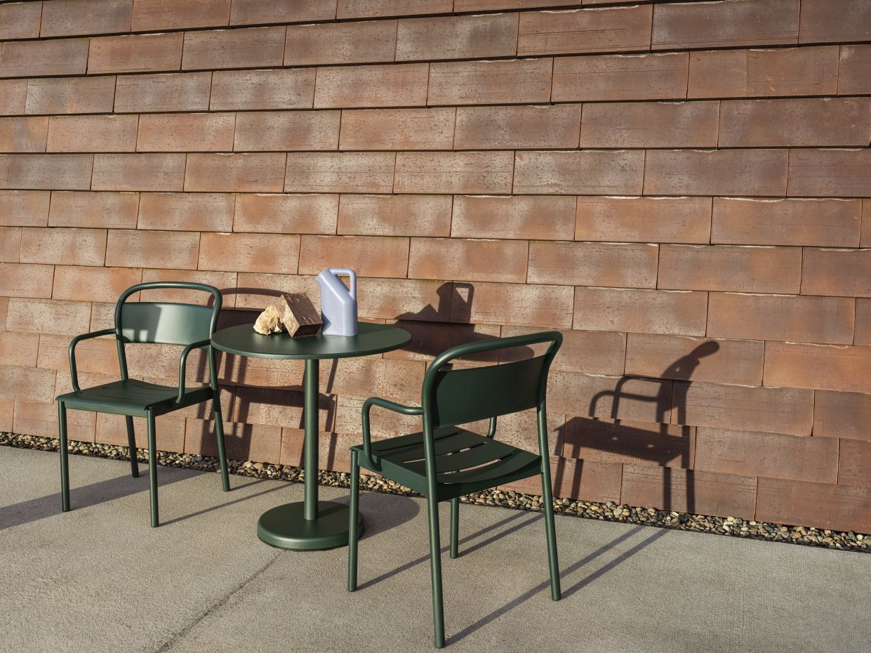 Muuto Linear Steel Café Table: Grüner Outdoor Beistelltisch mit zwei Stühlen und Gießkanne.