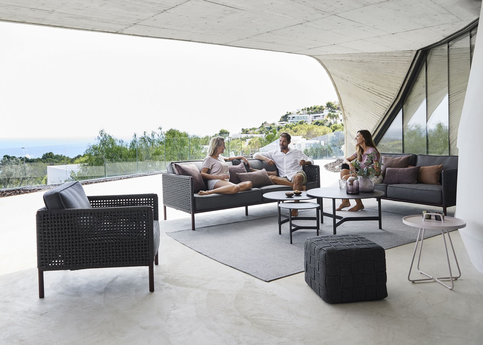 Encore Sofa von Cane-Line auf Terrasse mit Menschen. Gartenmöbel, Outdoor Sofa, Design.