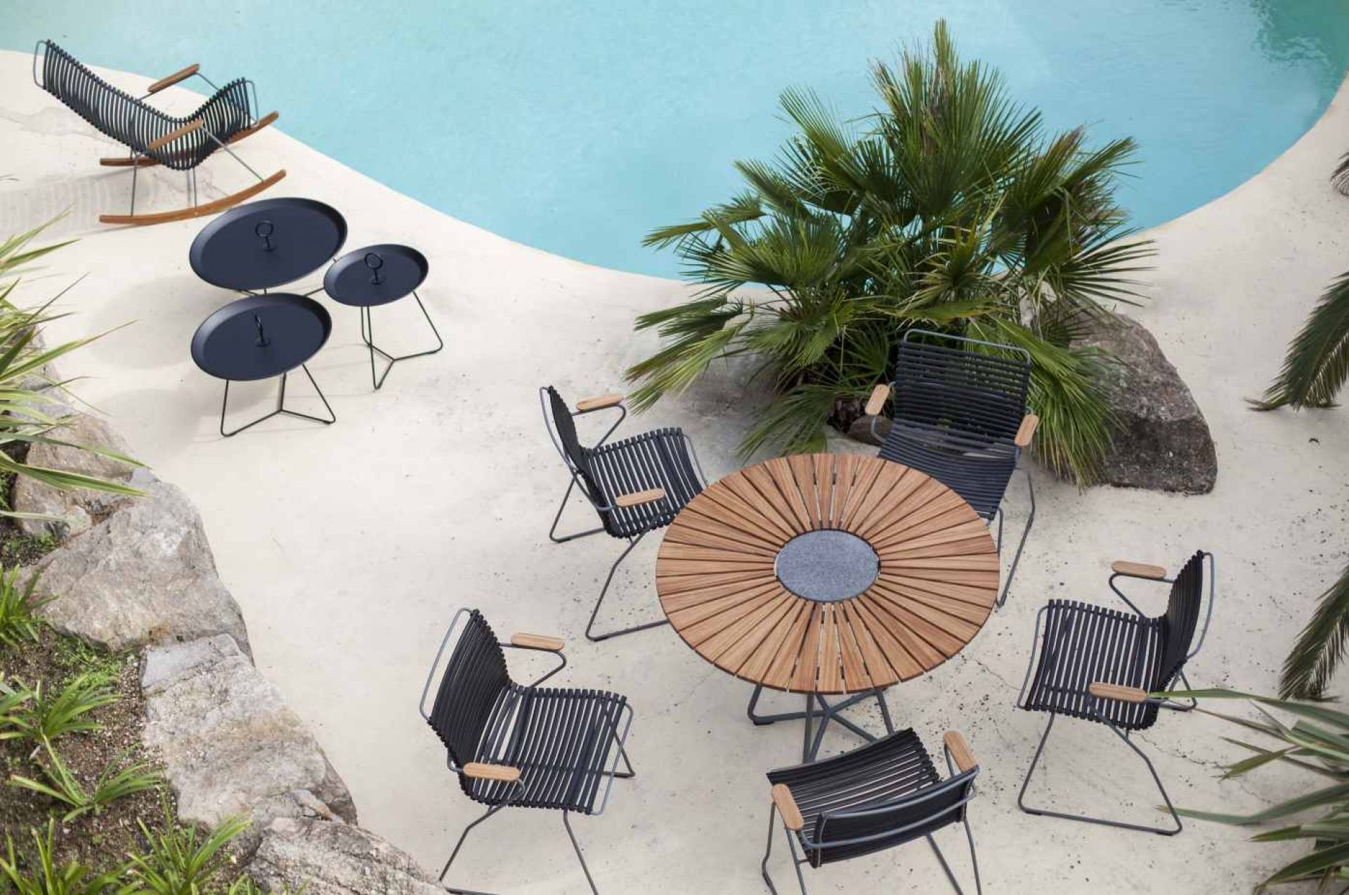 Houe Circle Outdoor Tisch Ø 110 cm mit Stühlen und Beistelltischen im Garten am Pool.