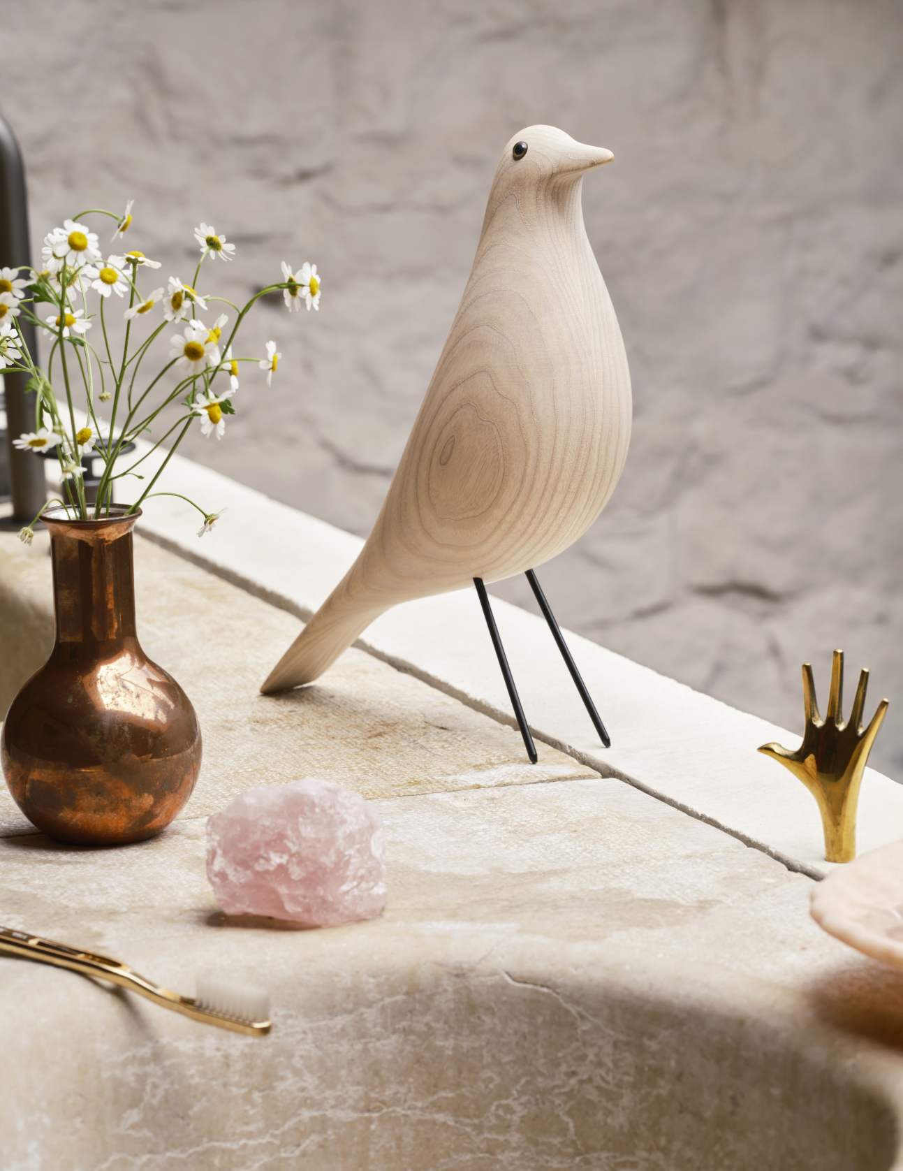 Eames House Bird Skulptur aus Esche, weiß geölt von Vitra, auf einem Tisch mit Dekoration.