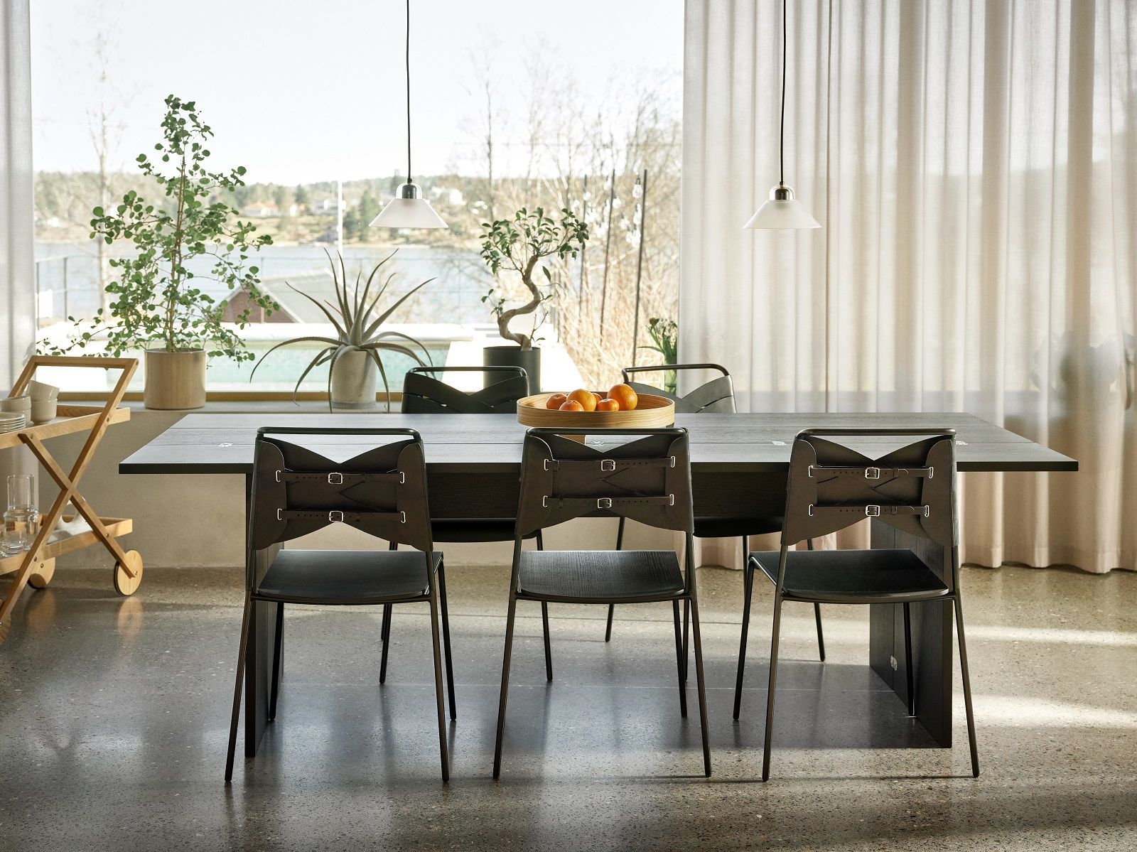 Esszimmer mit Kalo Lamp Pendelleuchten von Design House Stockholm und modernen Stühlen unter sanftem Licht.