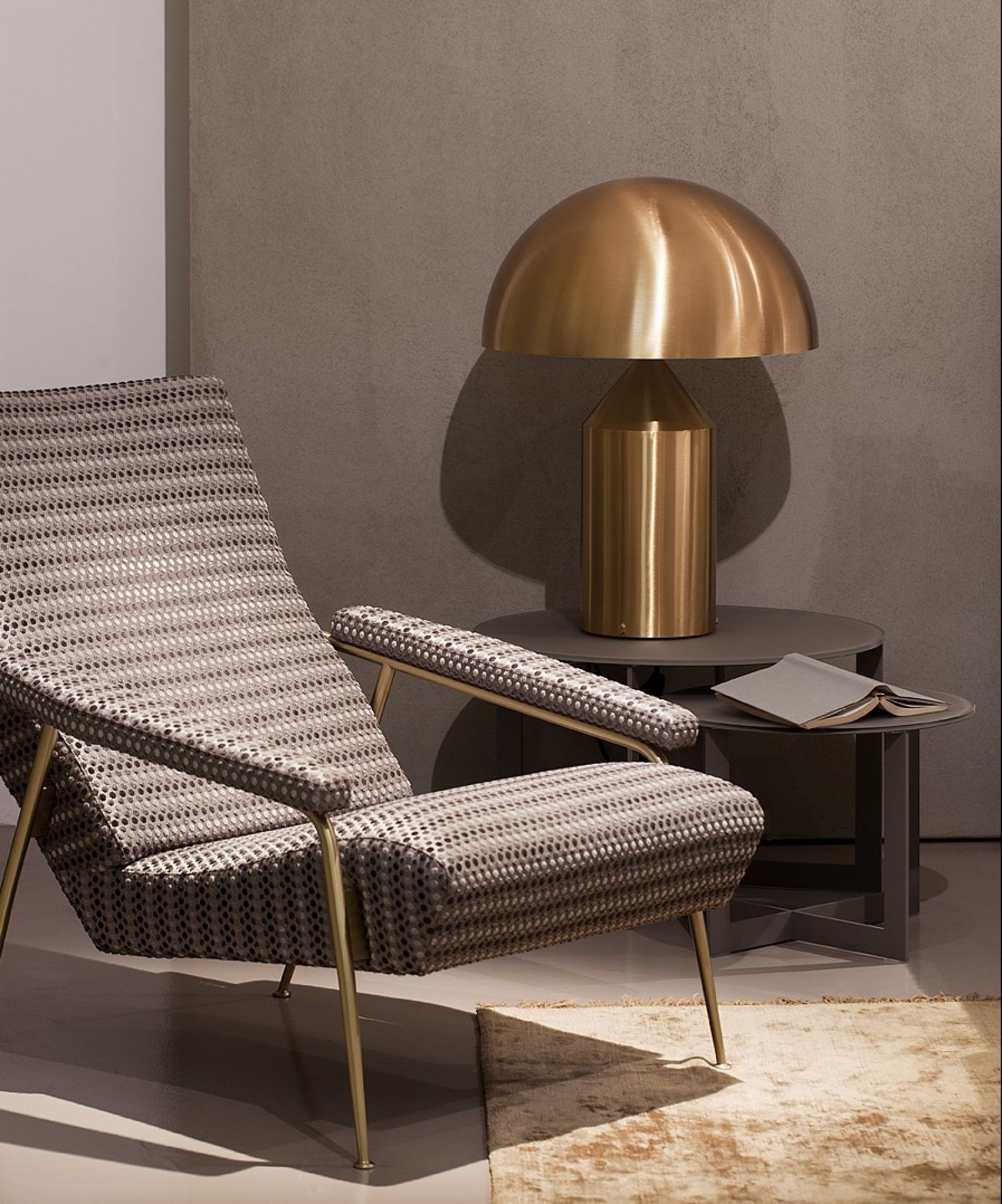 Goldene Atollo Tischleuchte von Oluce auf einem Beistelltisch neben einem Sessel. Design Lampe.